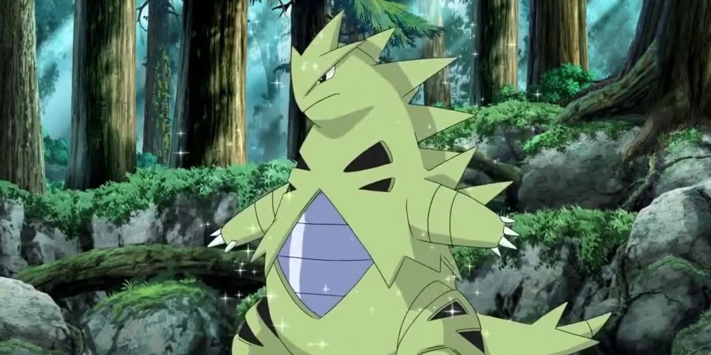 A Tyraniter standing in the forest in the Pokemon anime.