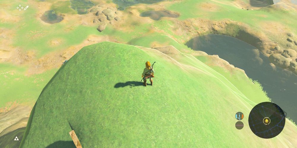 Link on a Hill in BotW, the Master Mode symbol (a triforce) is in the bottom left corner.