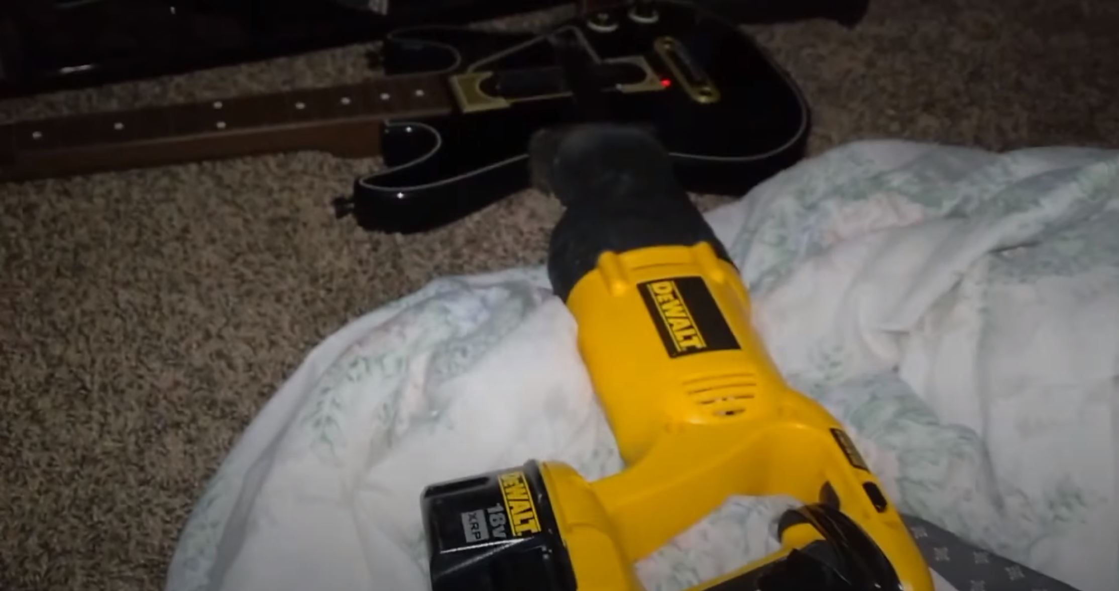 Reciprocating Saw Laying On Top Of A Guitar Hero Strum Bar