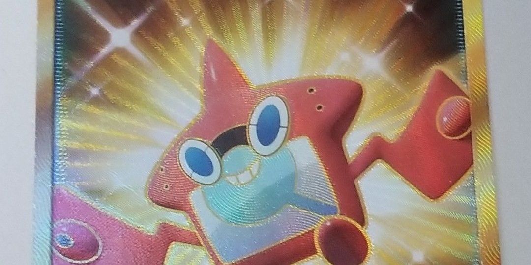 A closeup of Rotom Dex with a gold background