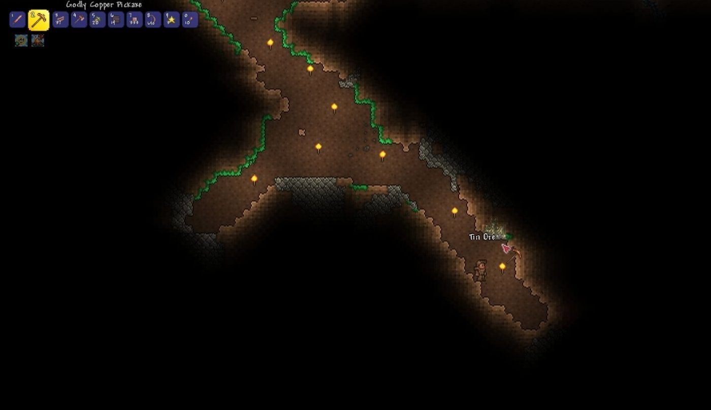 A screenshot of a Terraria player mining Tin Ore underground in a dug-out tunnel.