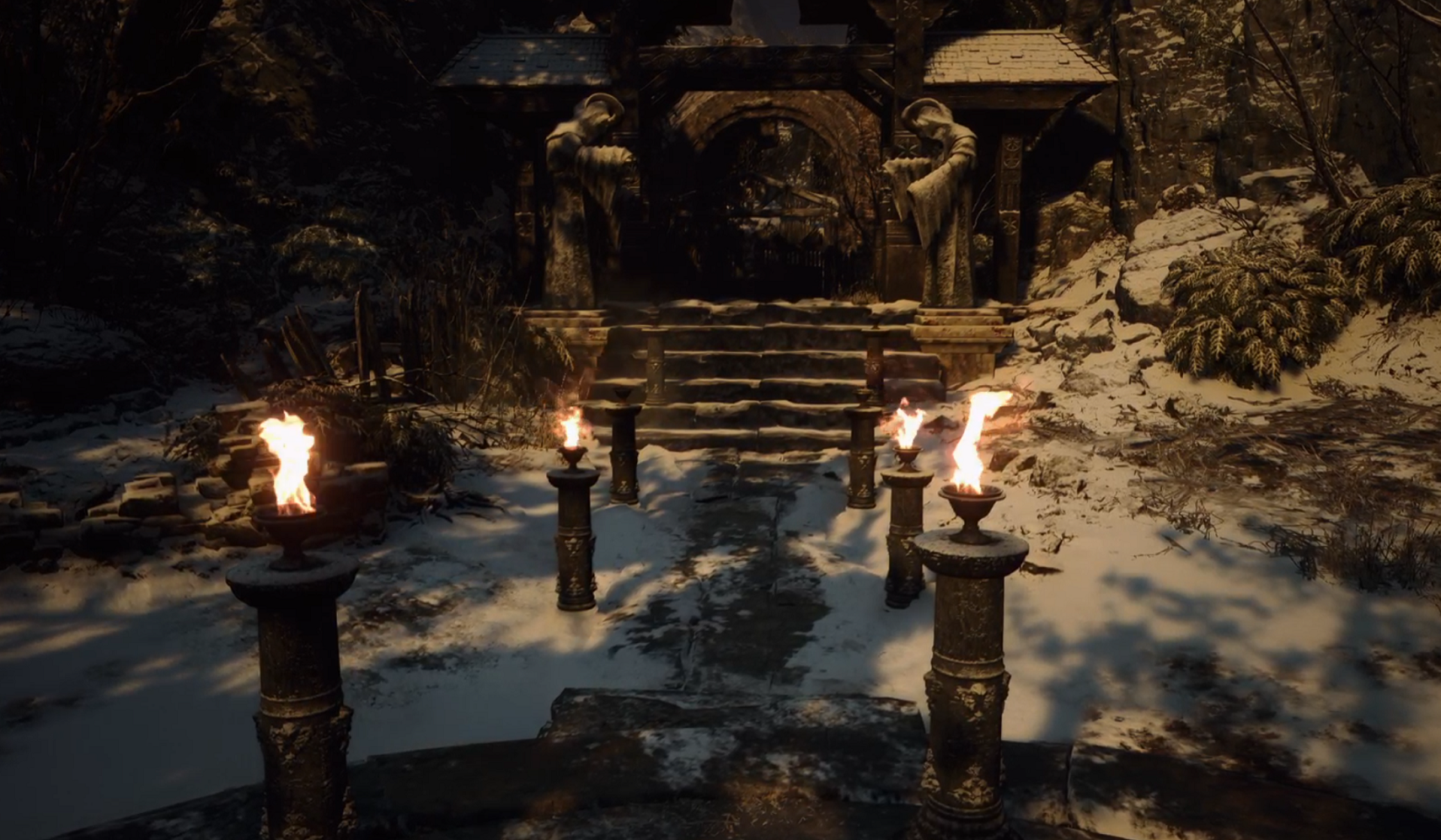 Torches light the way towards a door in Resident Evil Village