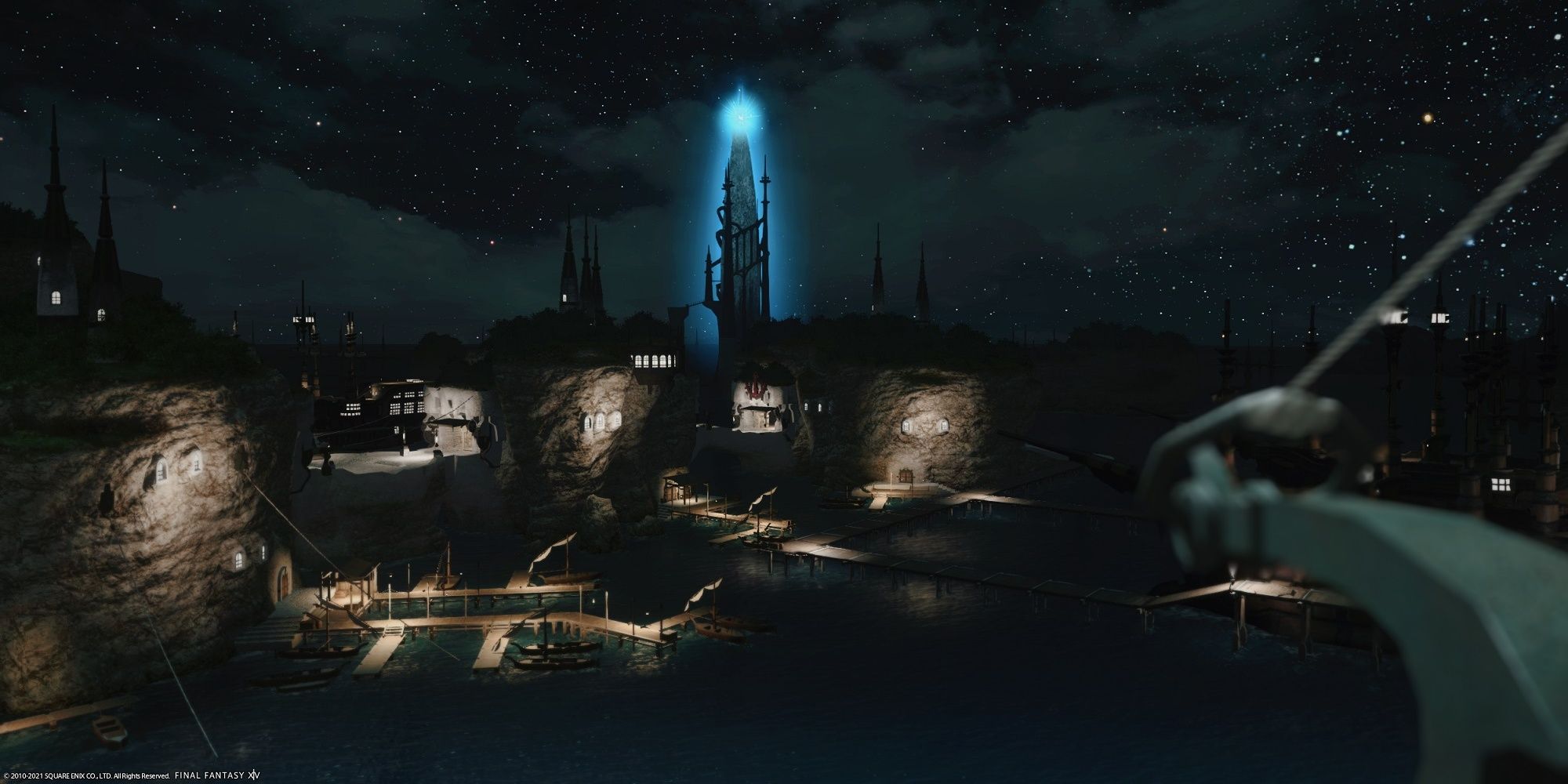 The lighthouse in Limsa Lominsa seed from a distance at night with cloudy skies and stars in background. The lighthouse looks like a tall blue crystal.