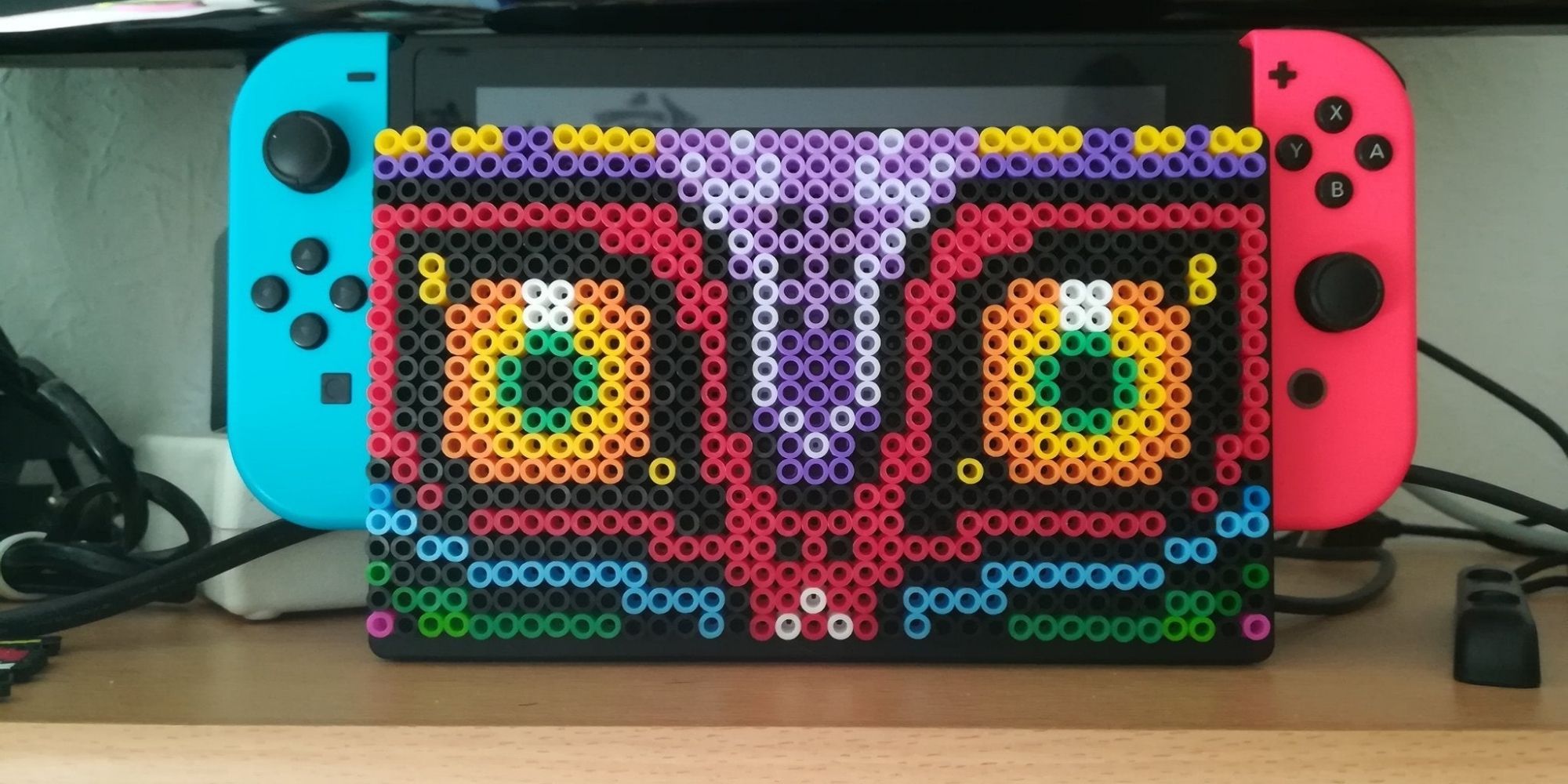 Majoras Mask made out of Perler Beads on a Switch Dock