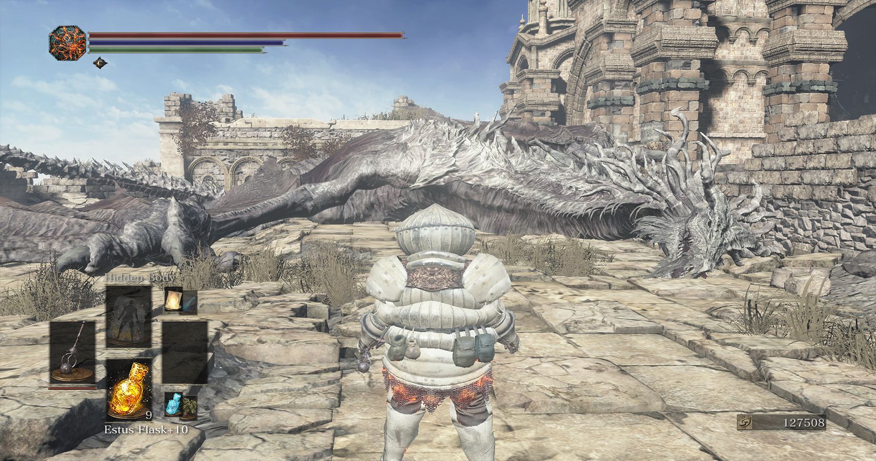 player standing near large dead dragon in ruins