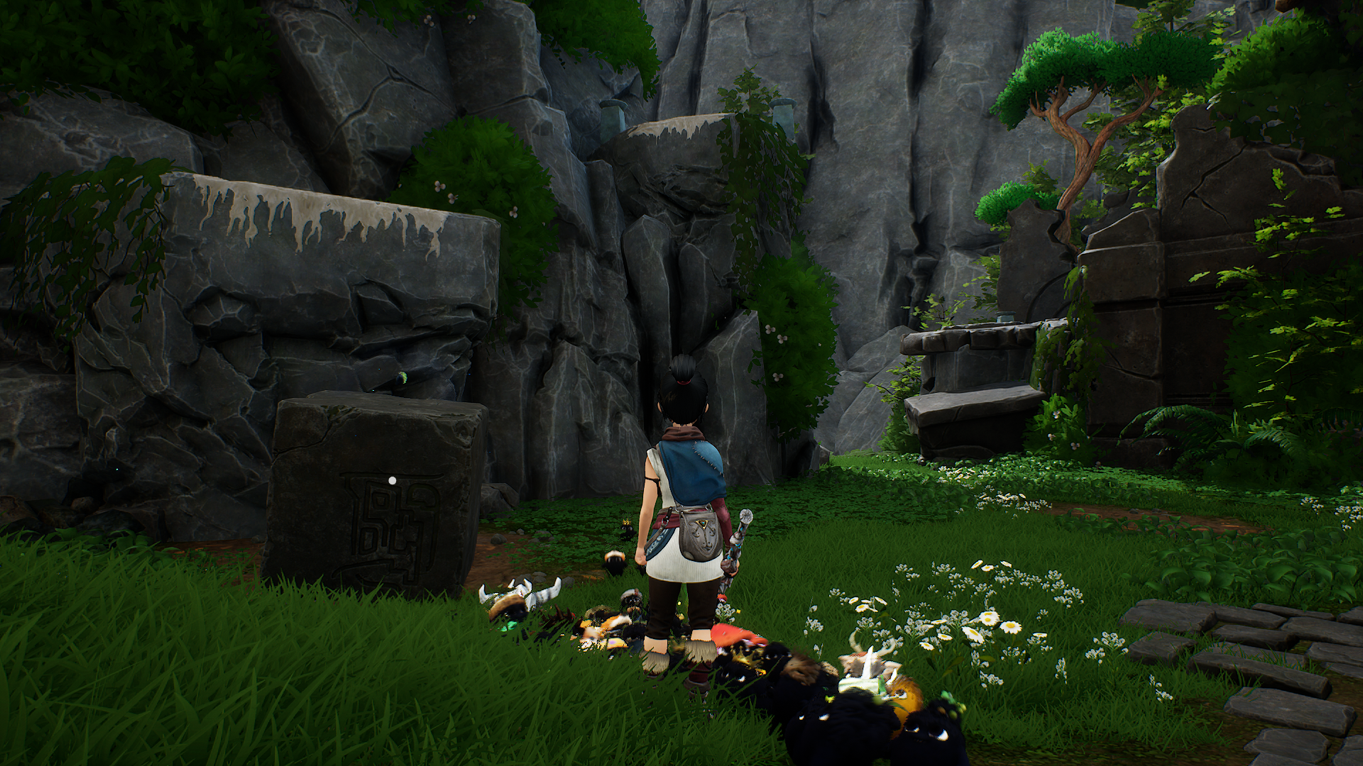 Kena stands in front of a cube-shaped rock, looking at a cliff edge.