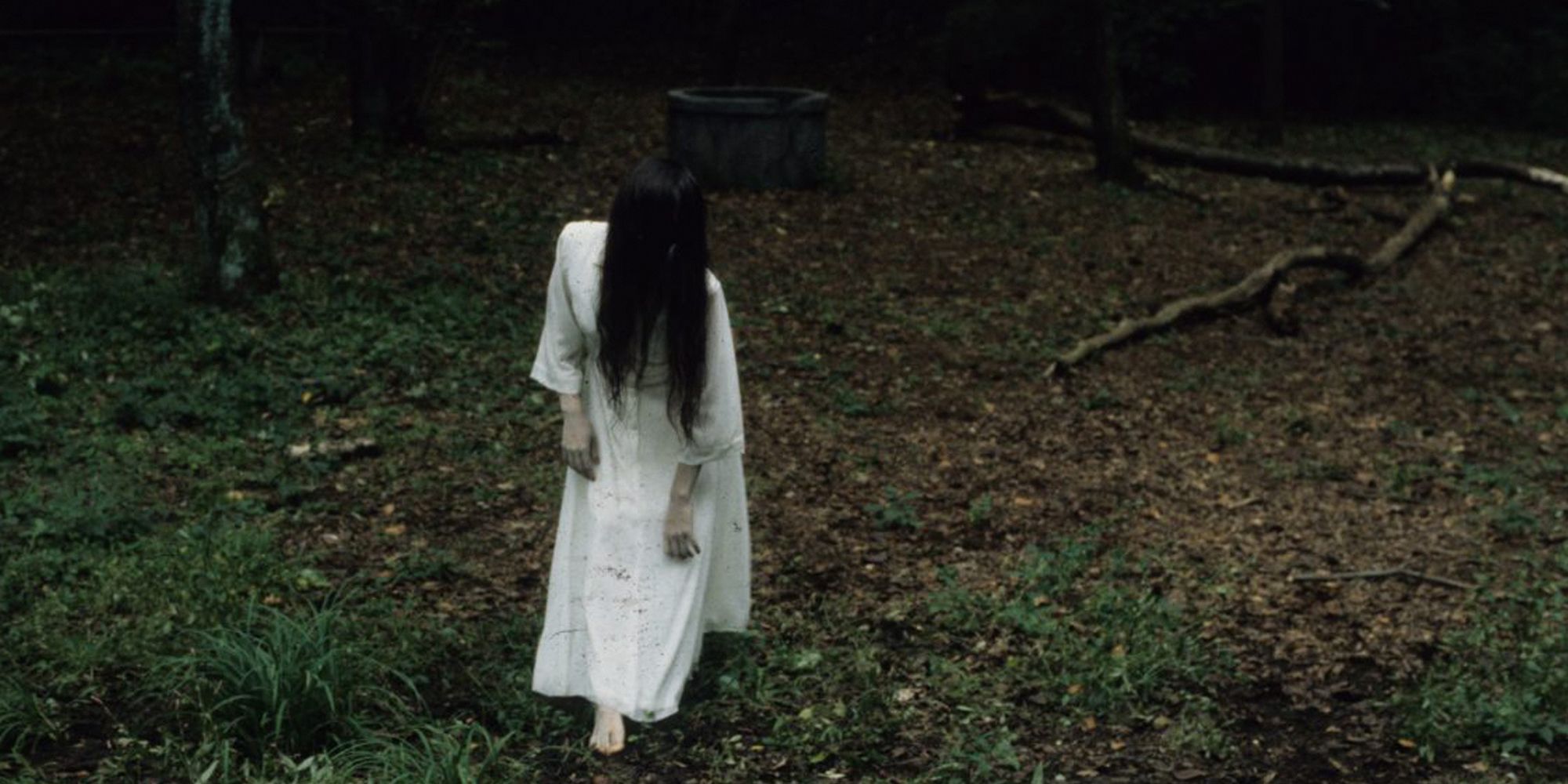 Sadako from Ringu. Girl in a white dress in the woods walking away from a well.