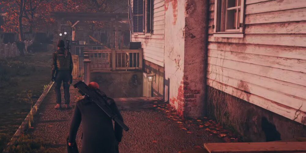 A Screenshot From Gameplay Of Hitman's Colorado Map Showing Agent 47 Sneaking Towards The Basement Entrance.