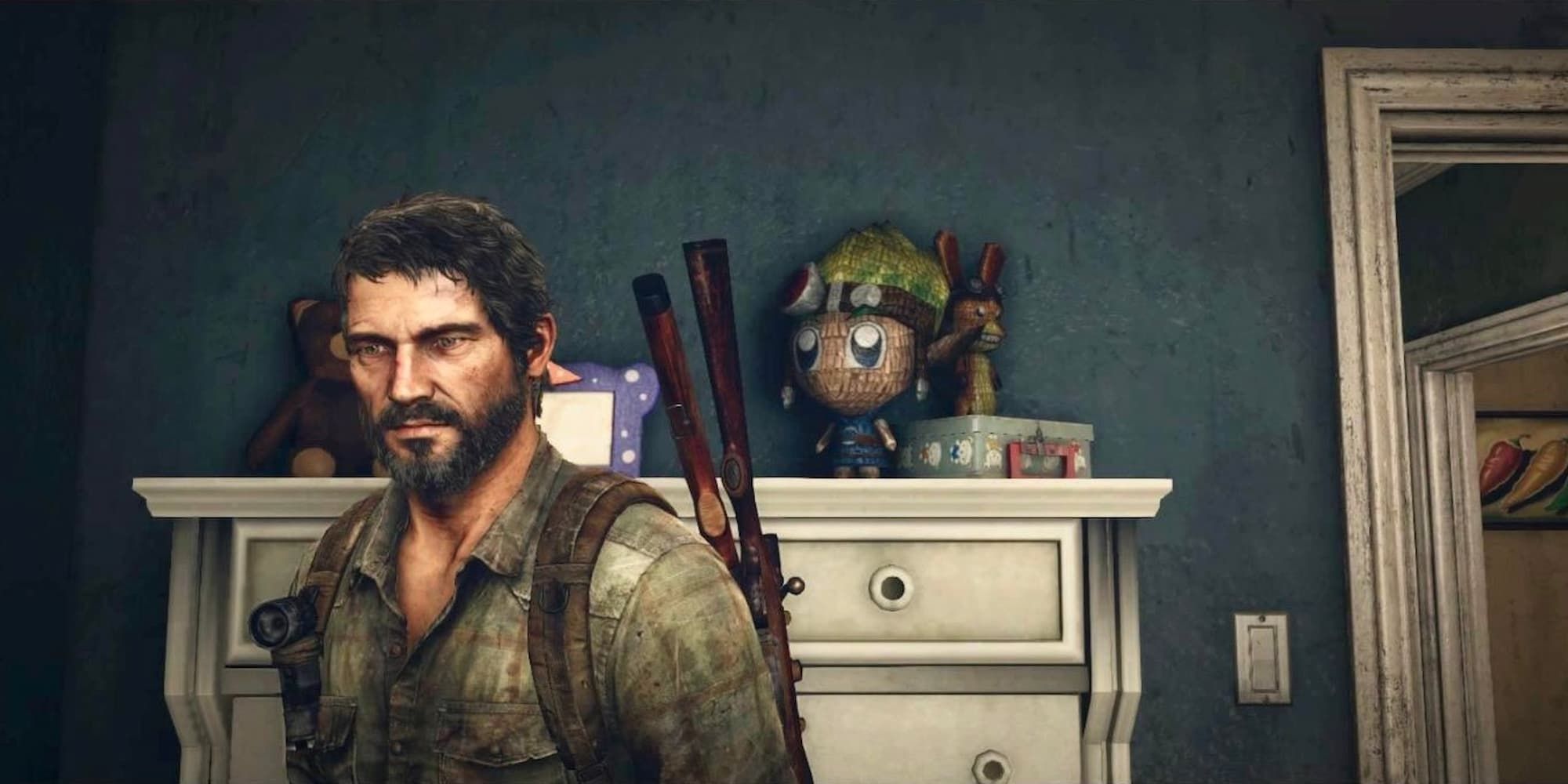 Joel looking towards the camera with toy figures of Jak and Daxter behind him
