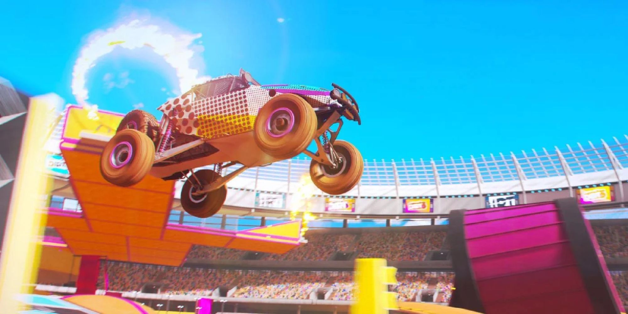 A buggy jumps from a high ramp in front of a ring of fire in Dirt 5's Playground mode