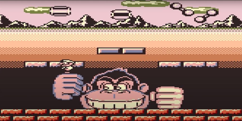 A large ape tries to crush a mustachioed man
