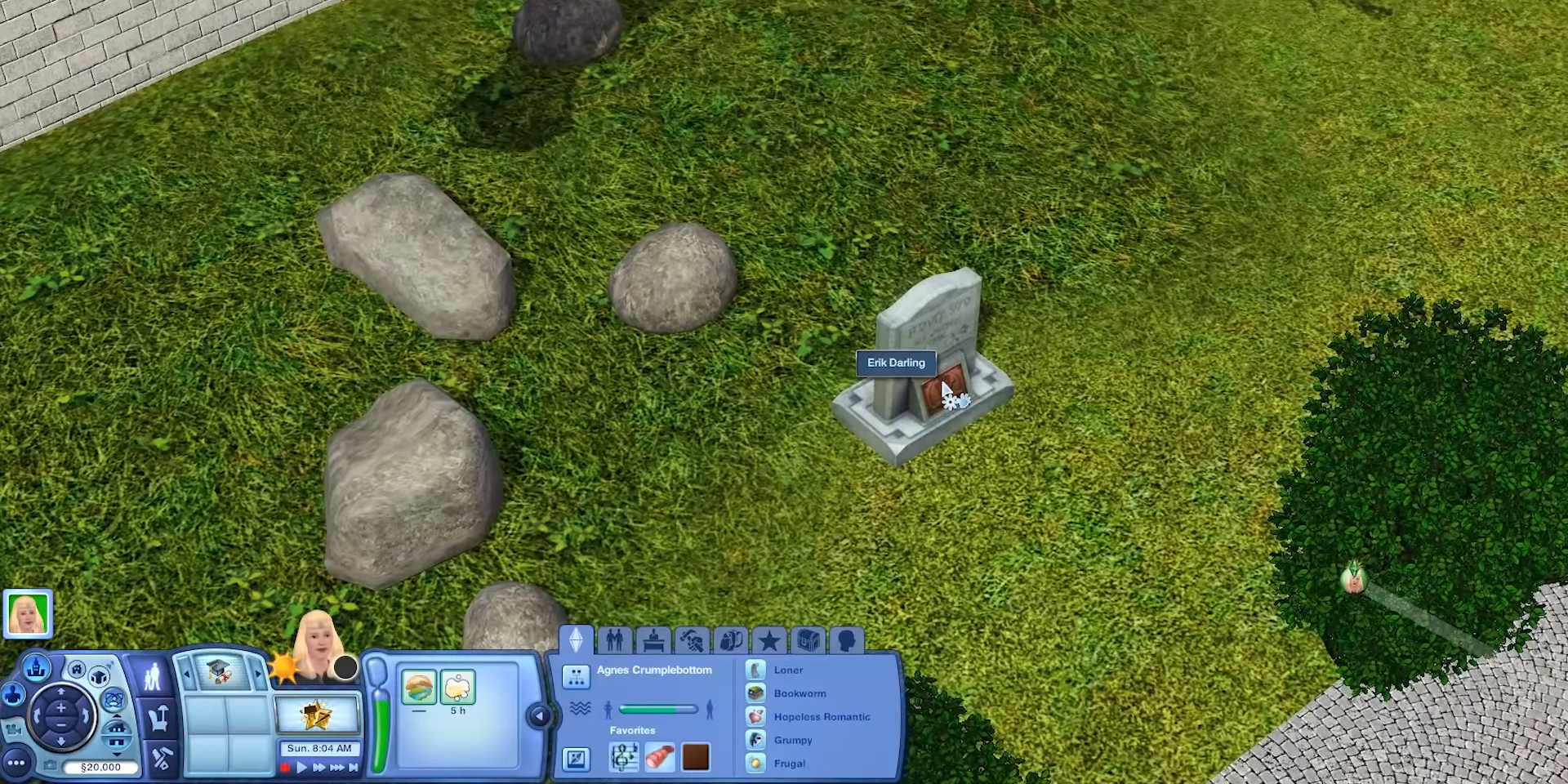 An aerial view of Erik Darling's grave in The Sims 3, surrounded by rocks and sitting perpendicular to Agnes Crumplebottom's driveway