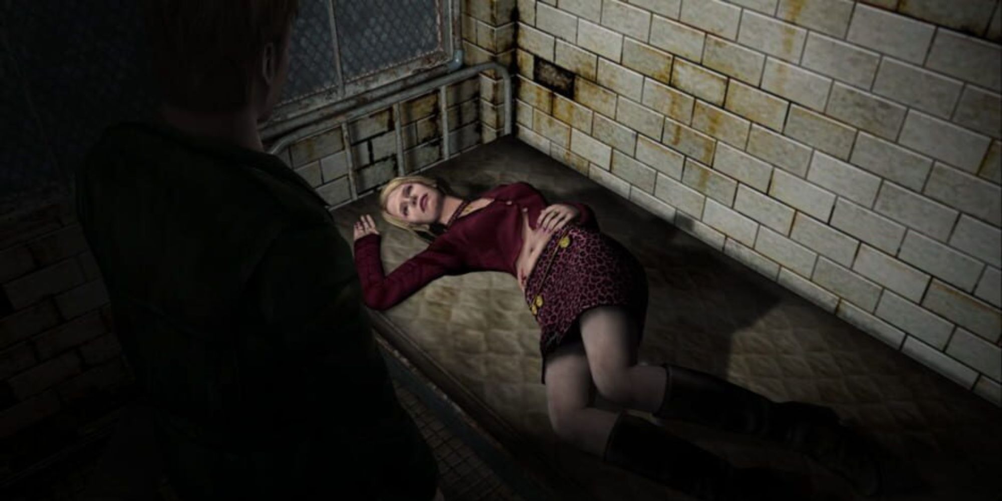 James stands over a bed looking at Maria lying down on it
