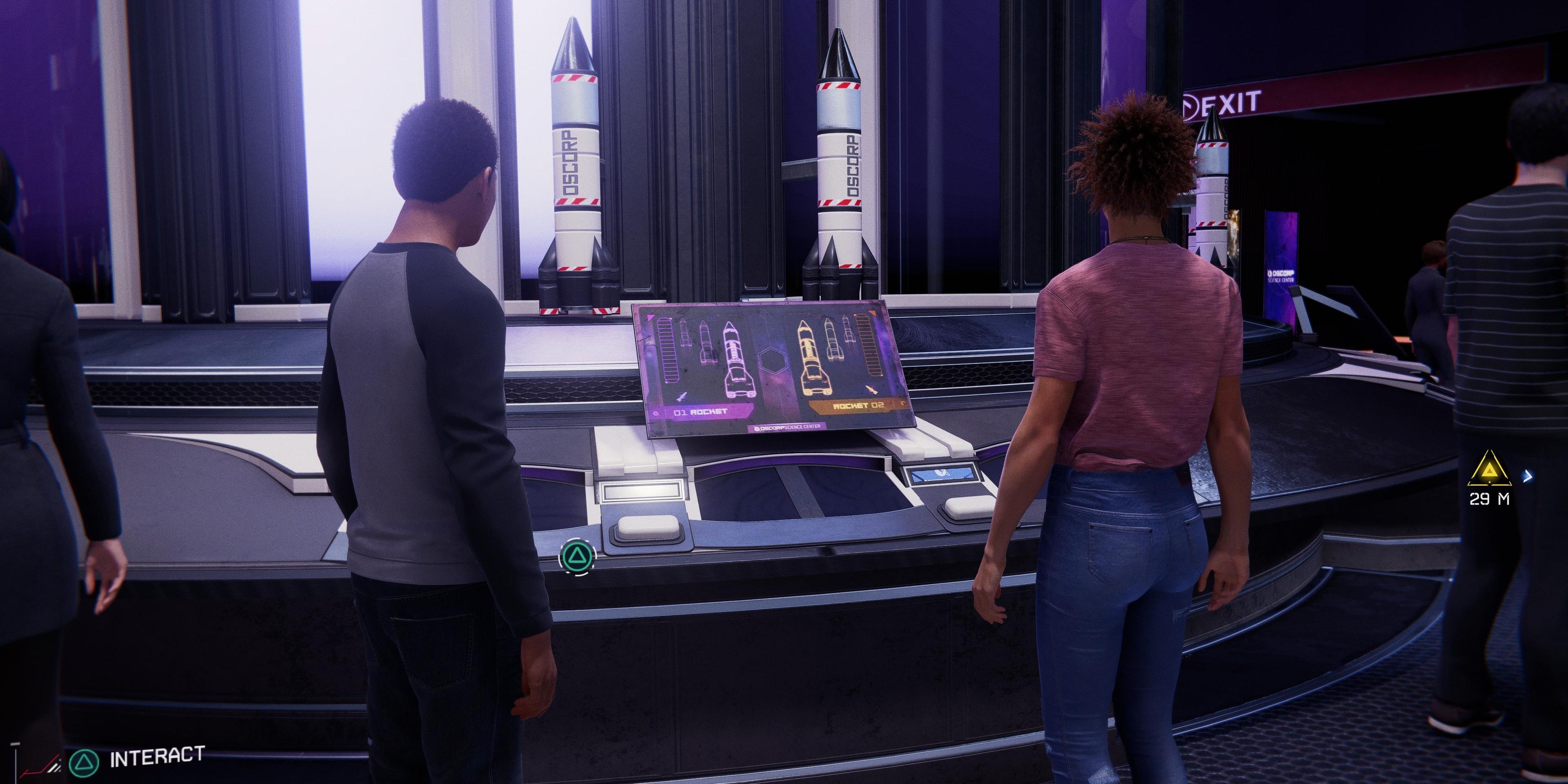 miles and phin standing in front of rocket game in Oscorp Science Museum