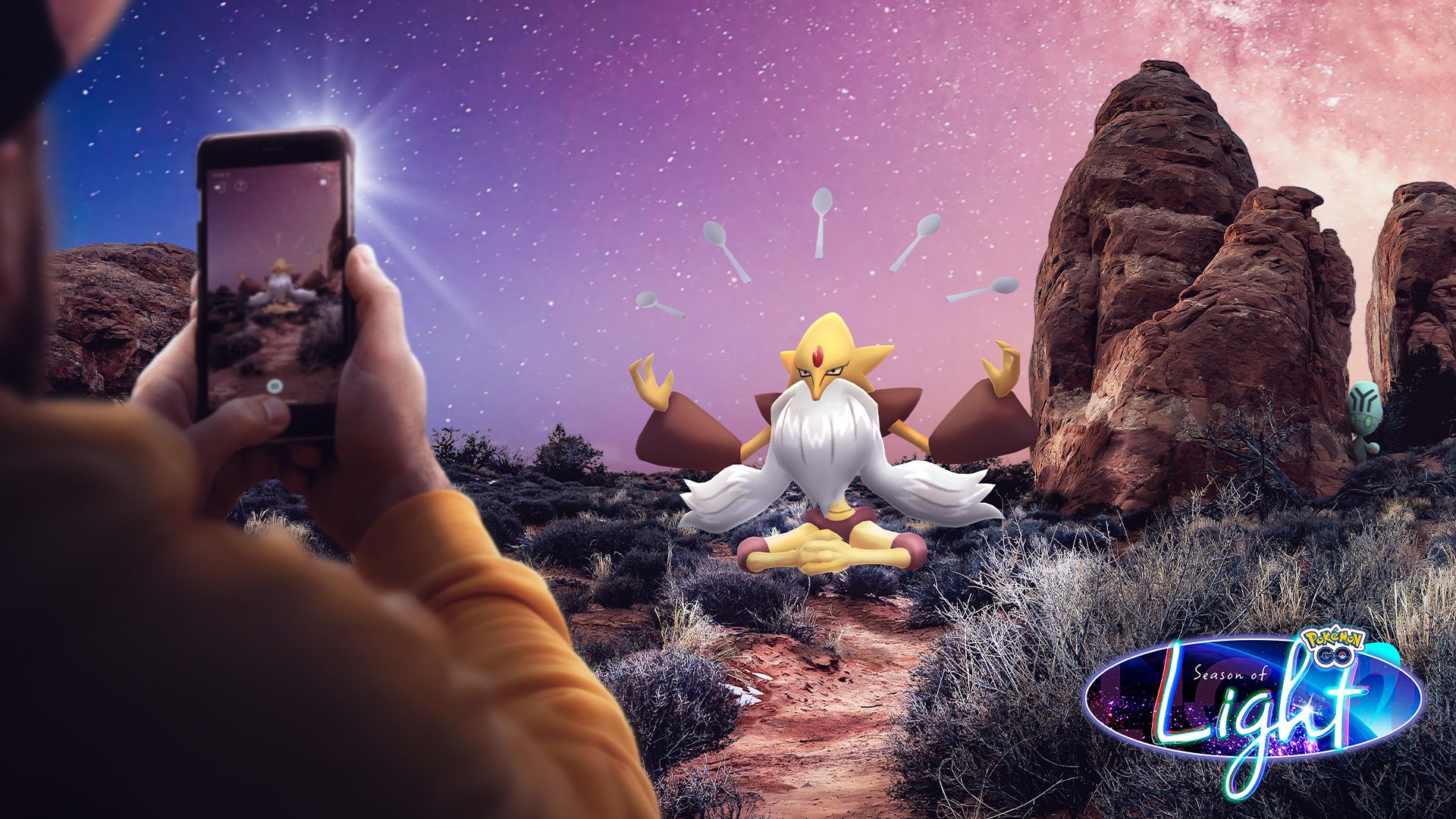Image of Mega Alakazam with someone pointing their cell phone at it, playing Pokemon Go