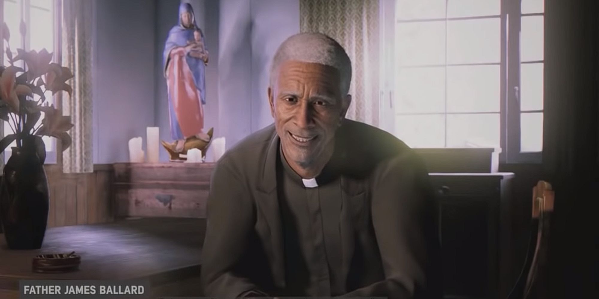 Father James smiles while he leans forward on his chair, talking to the documentary crew