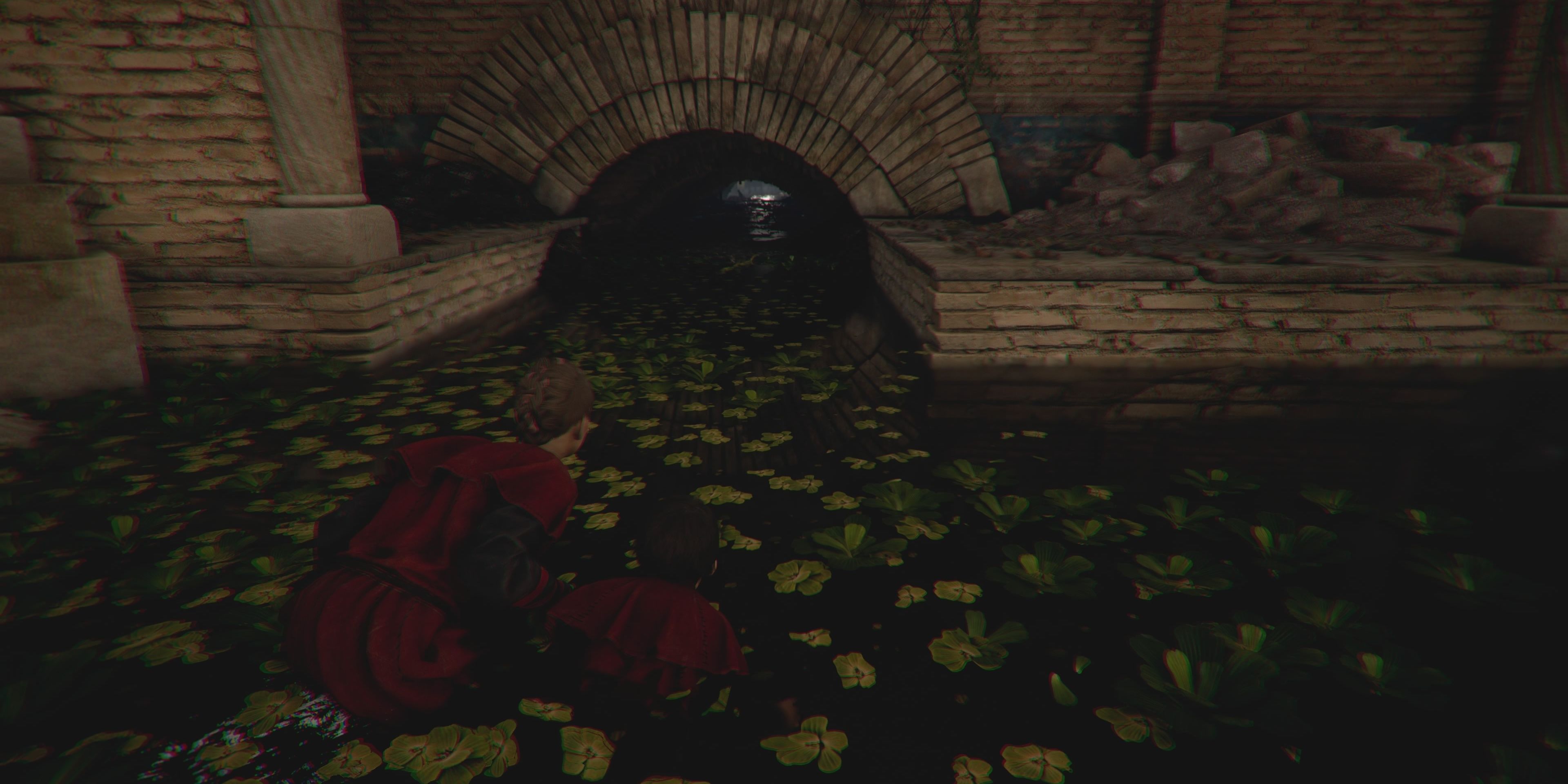 amicia and hugo walking through the sewer
