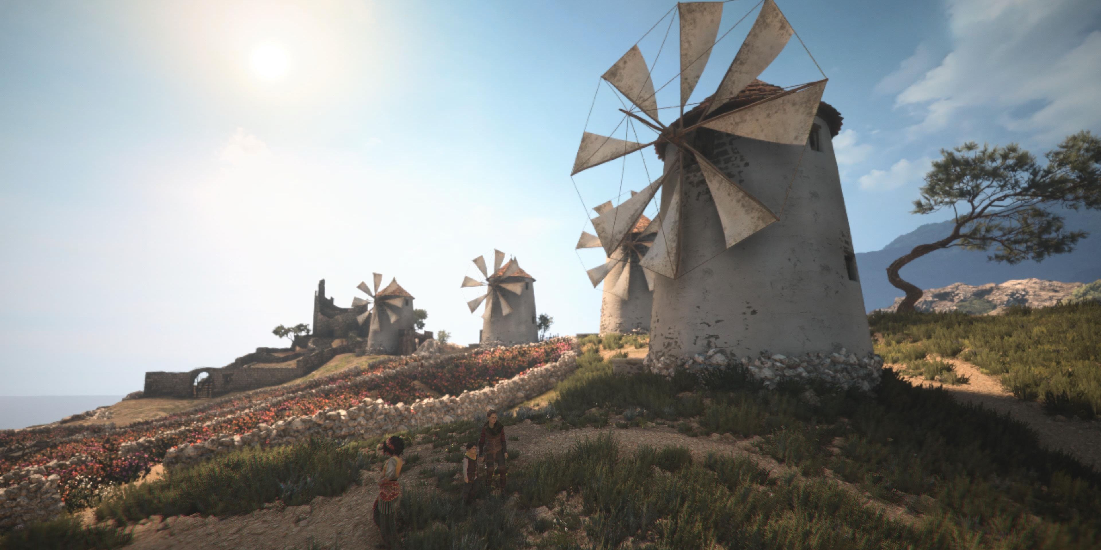 amicia, hugo, and sophia standing in front of the windmills