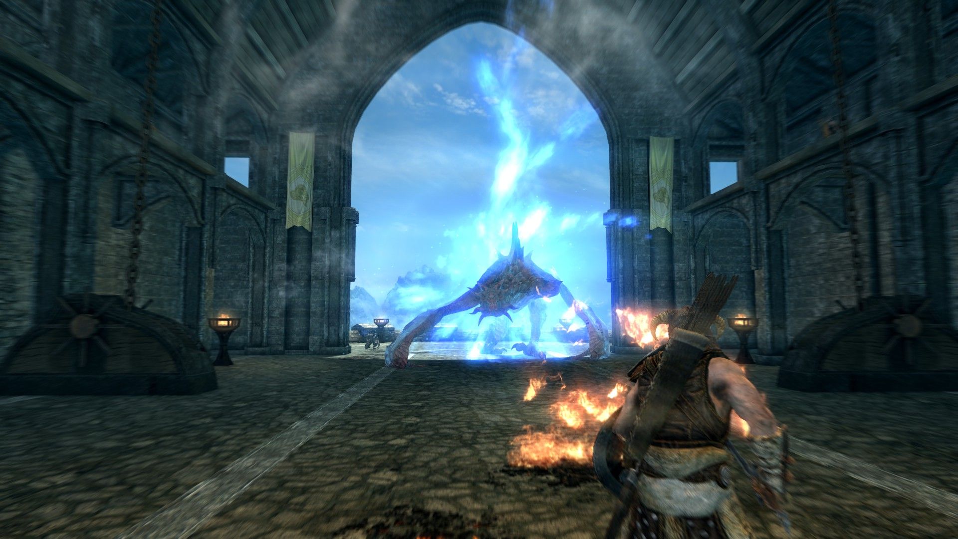 A man challenges a dragon inside a stone castle with patches of ground burning