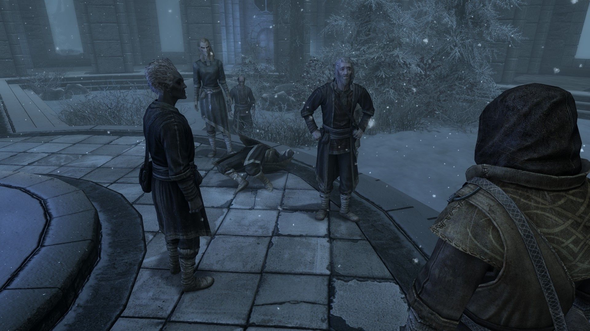 A group of mages speak next to the corpse of a mage on a snowy day.