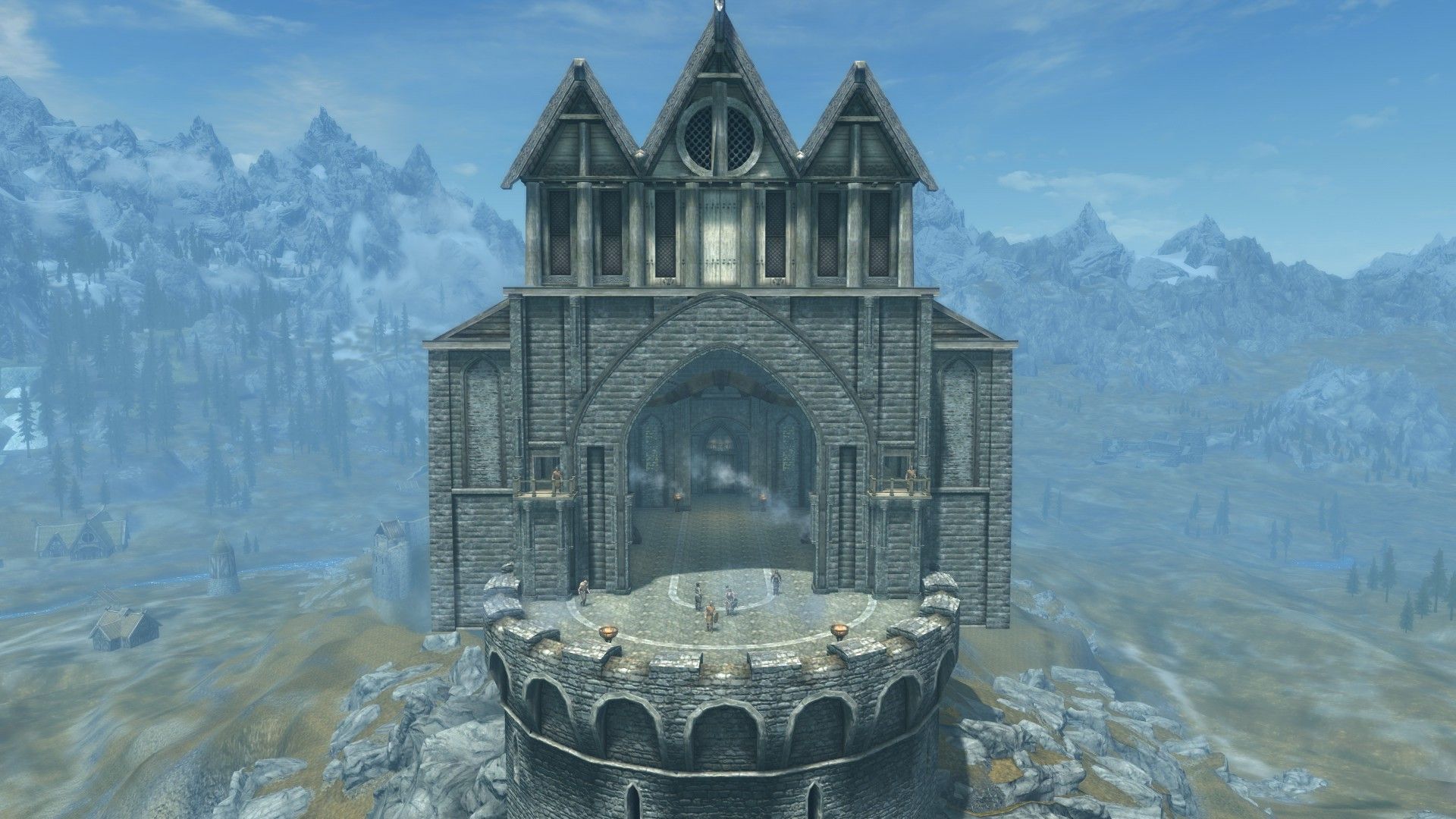 A stone castle is perched on top of a mountain, showing a grand hall overlooking surrounding plains