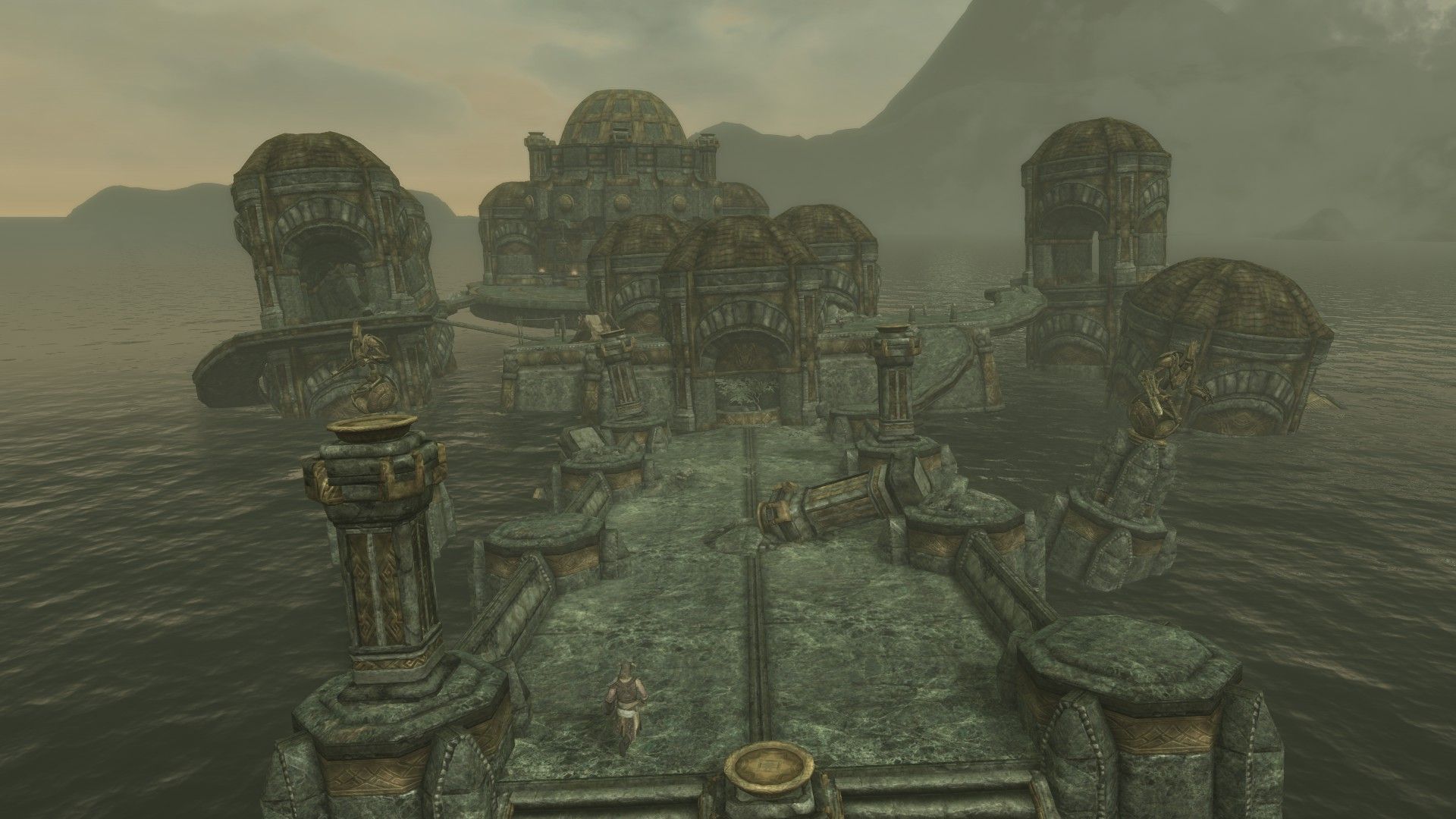 A man runs across a bridge to reach collapsing stone towers sinking into the ocean.