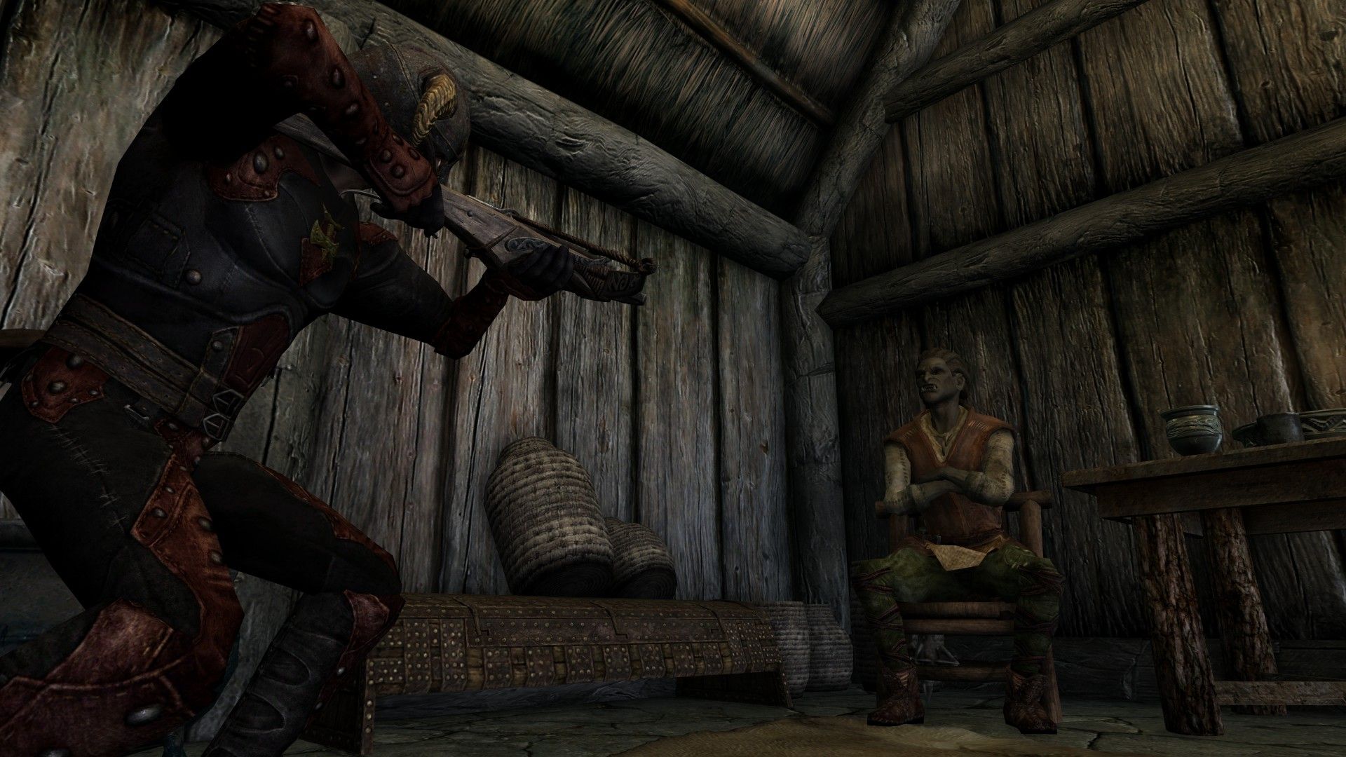 An assassin dressed in black and red tights aims a crossbow at a bard crossing his arms in defiance.