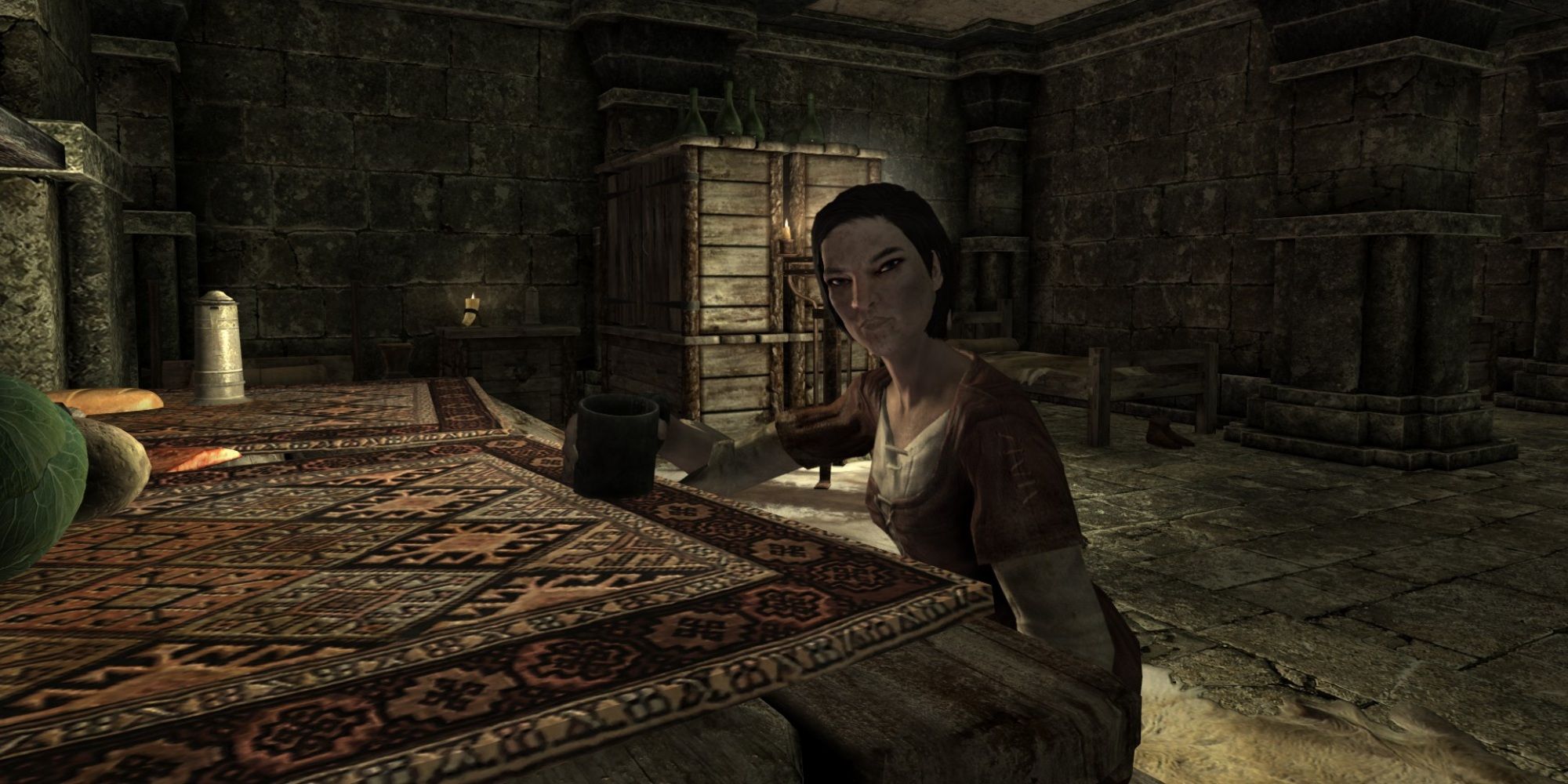 Skyrim screenshot of NPC Erdi sat at a table in her quarters.