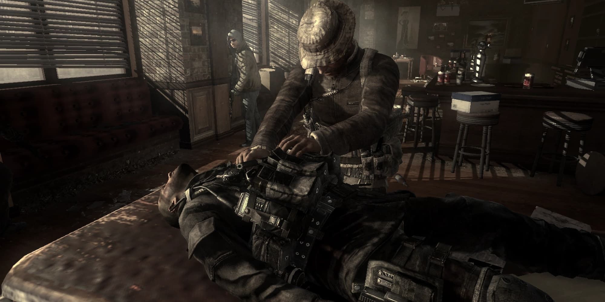 Soap lies on a table, deceased, with Captain Price standing over him mourning.