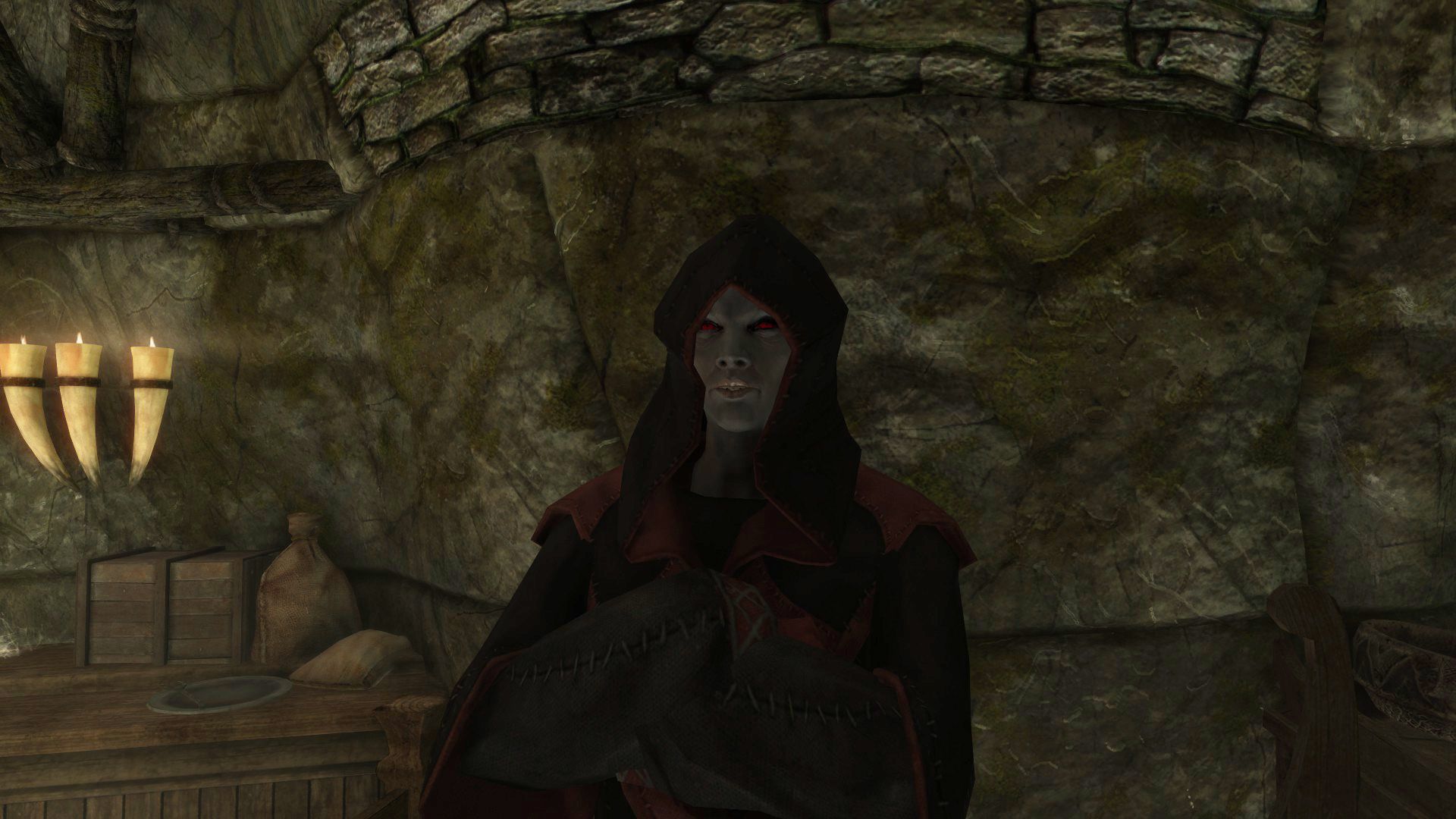 A dark elf woman dressed in menacing robes glares at the viewer with her arms crossed.