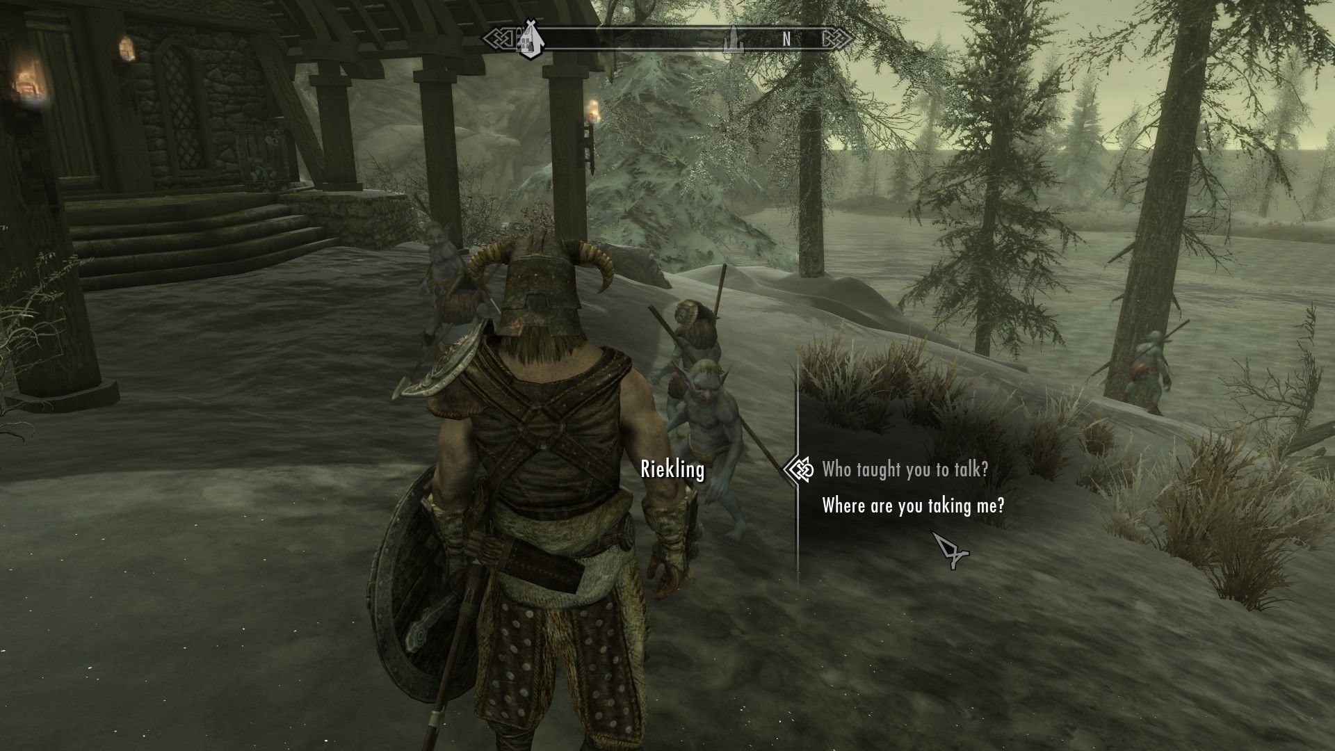 A screenshot of an adventurer speaking to a small Riekling in front of a mead hall.