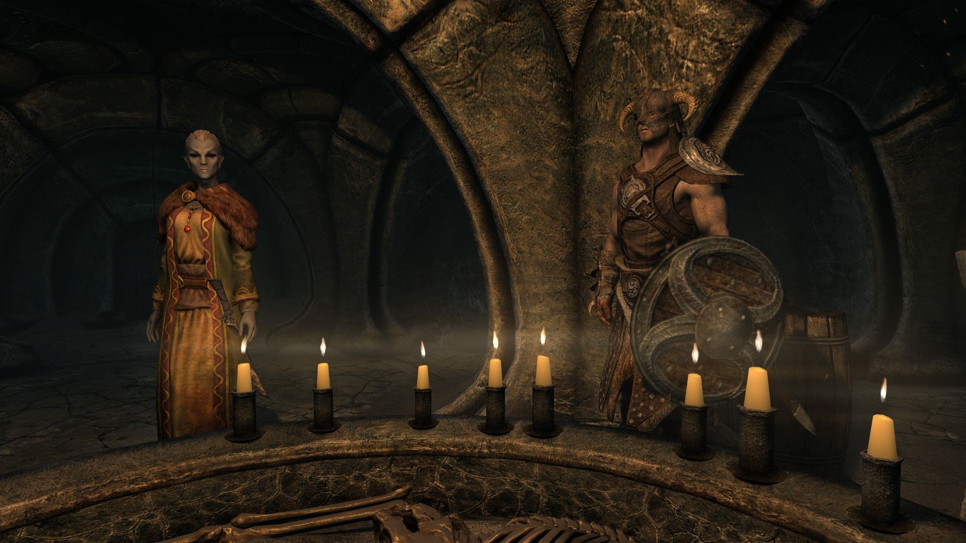 Two people stand over an ancestral tomb in an underground room lit by candles.