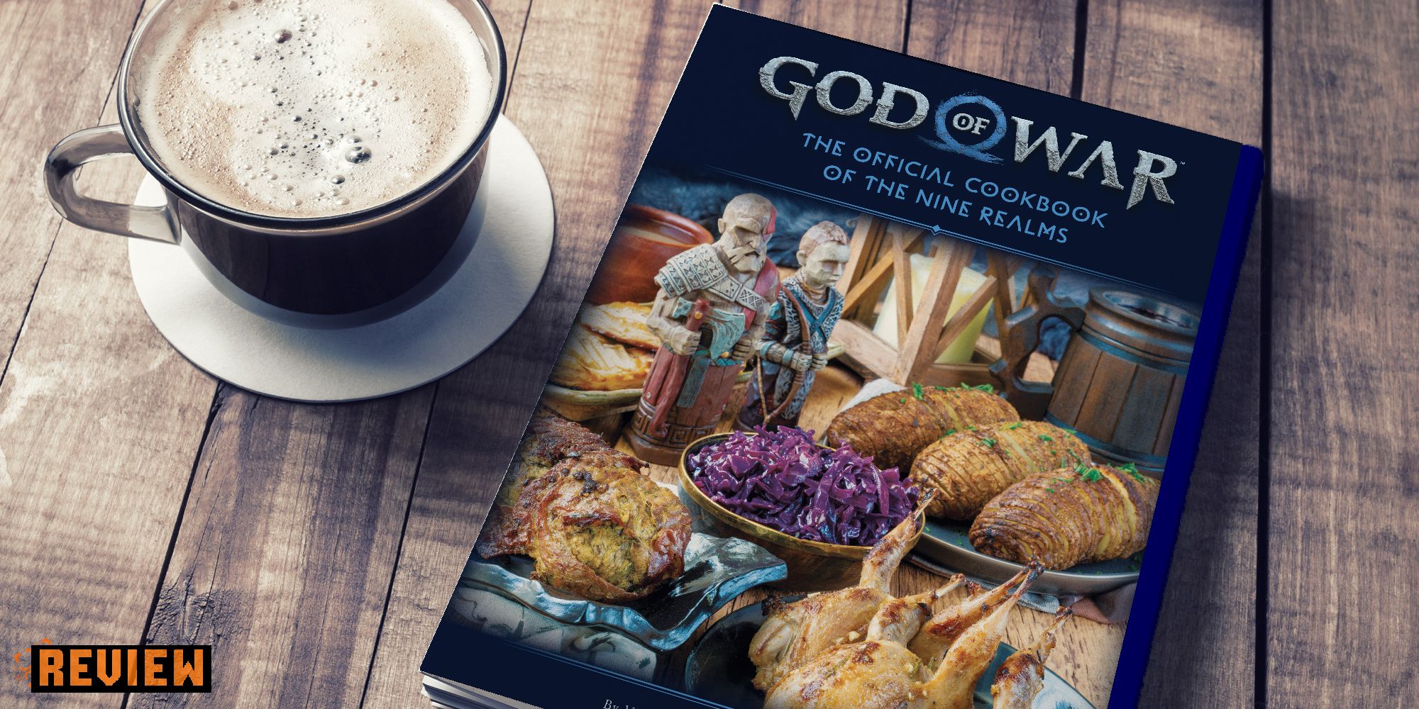god of war cookbook on a table next to a cup of coffee