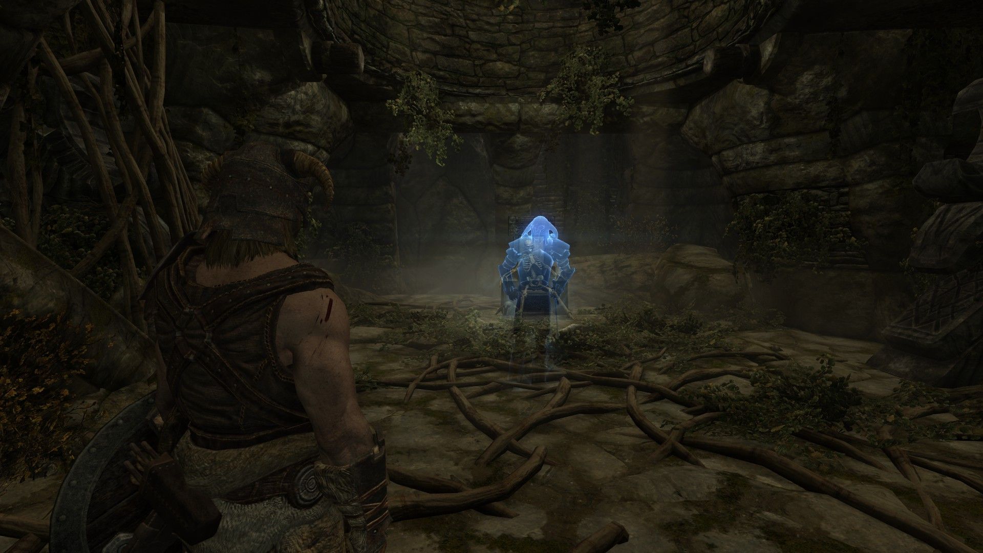 A ghost approaches a wounded warrior for help inside a crypt.