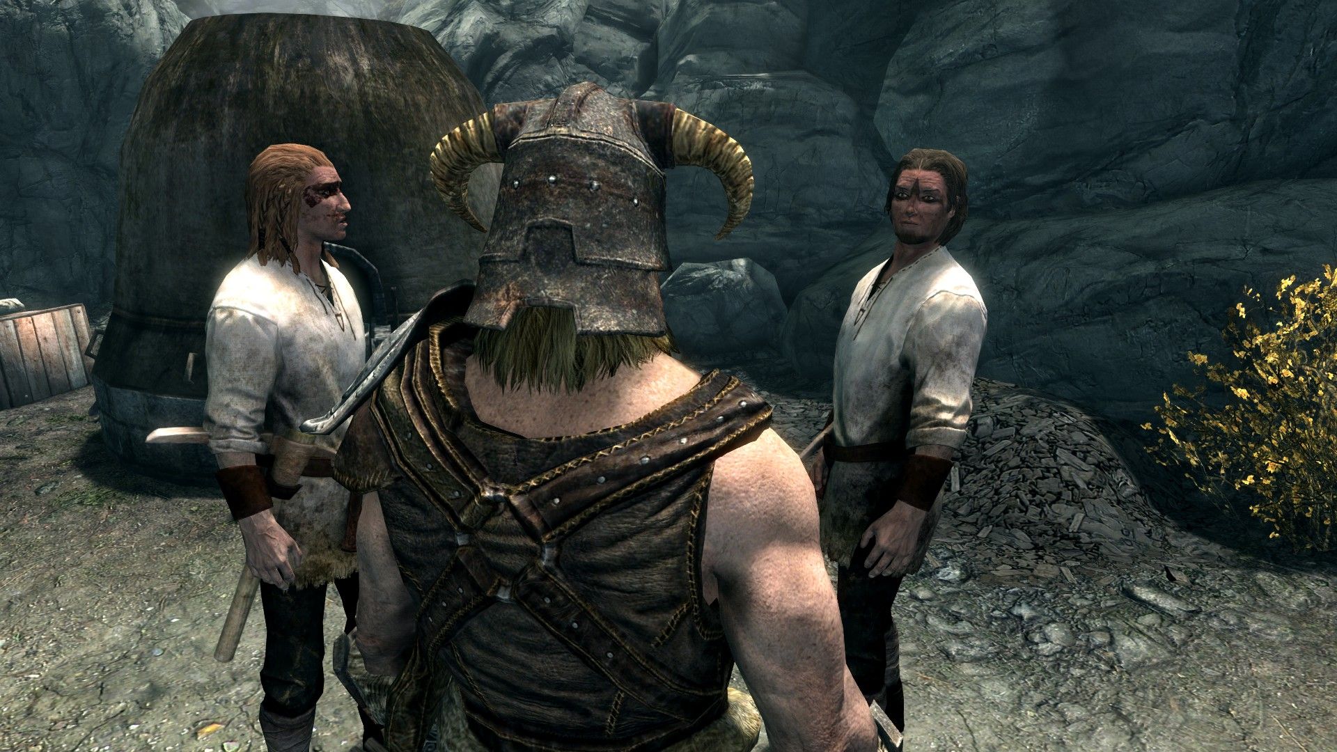 A man with a metal, horned helmet speaks to a pair of miners by a smelter.