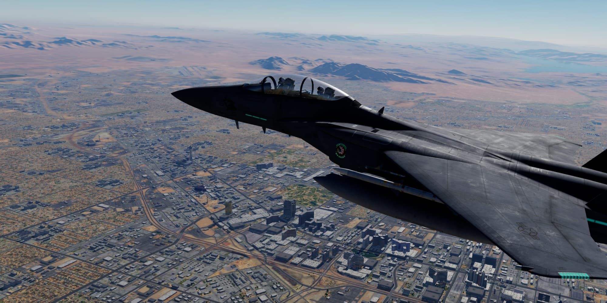 A black fighter jet flies above a city in DCS World.