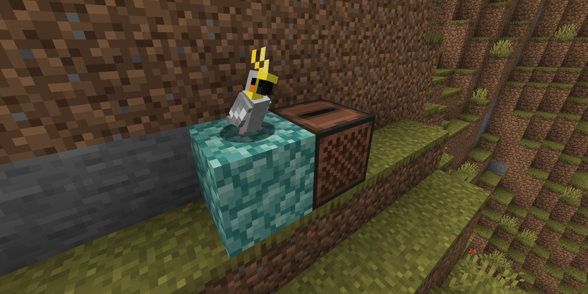 A parrot dancing on a prismarine block standing next to a jukebox playing music in Minecraft