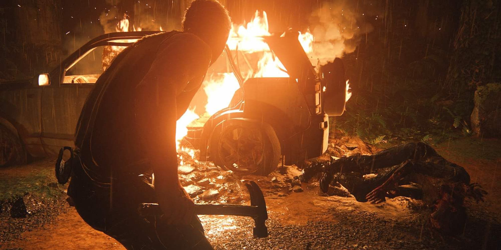 Joel approaches a burning car in the rain while holding a hammer in The Last of Us Part 2.