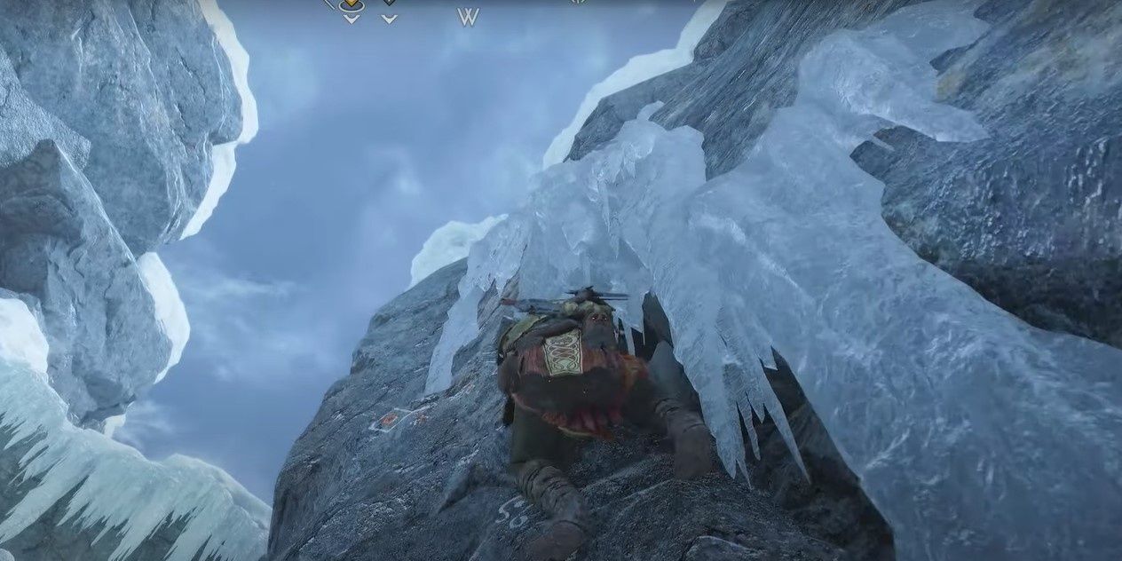 3 Kratos climbing a rock wall in the Well of Urd area of Midgard-1