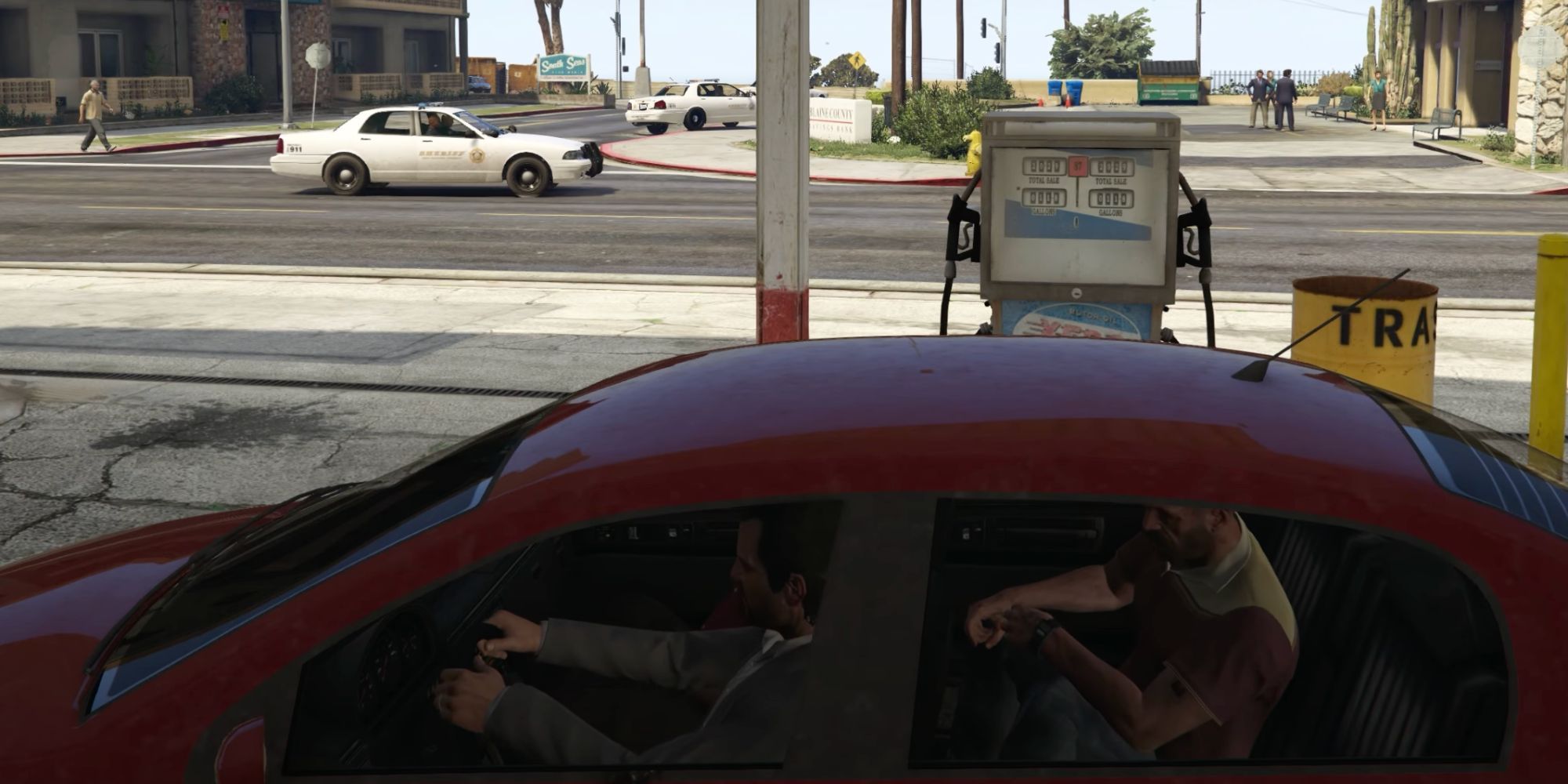 Michael, Franklin, and Trevor Watch From Red Car at Gas Station As Police Arrive in Grand Theft Auto 5 