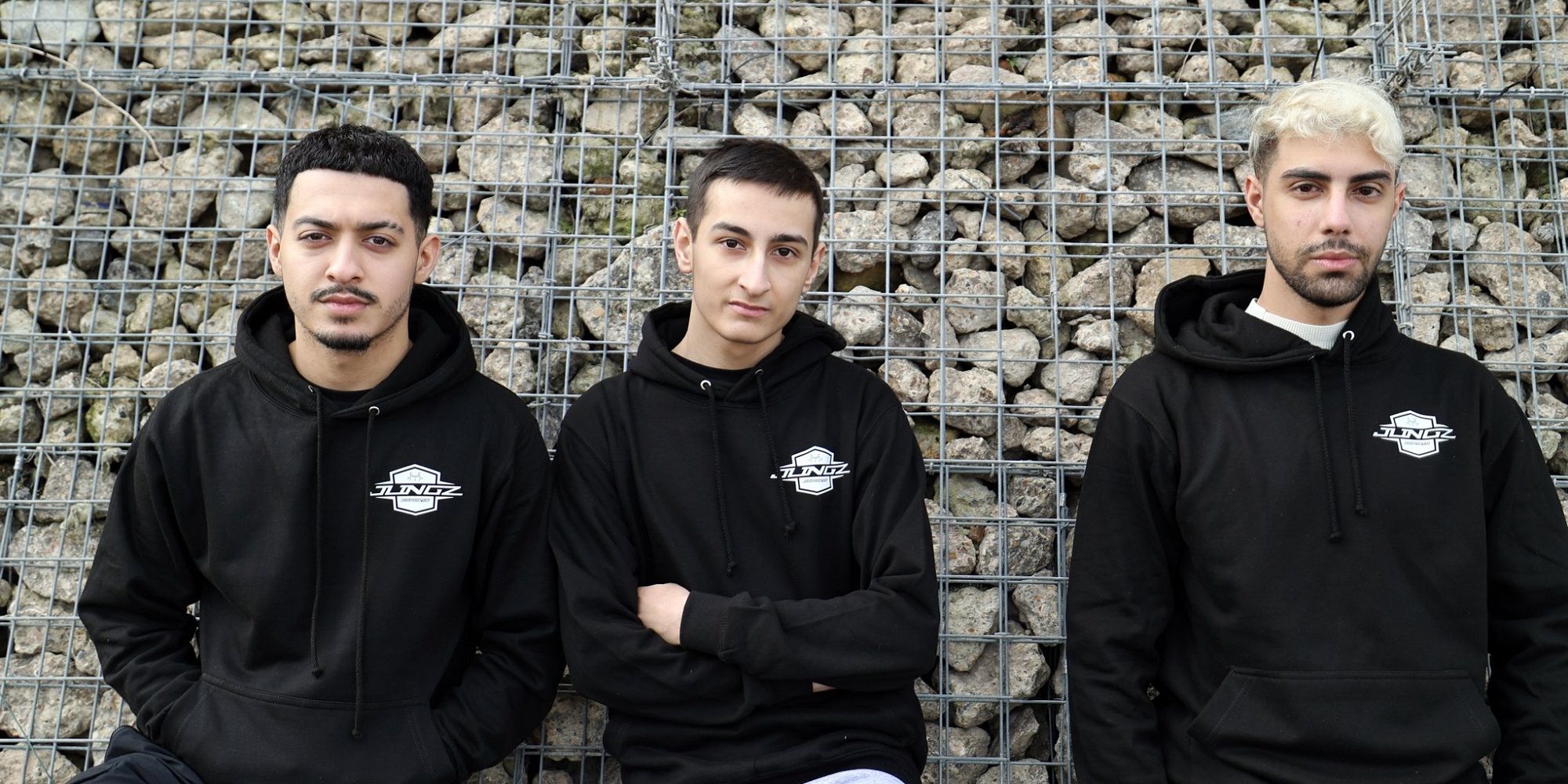 JLINGZ esports team stands in front of a stone wall
