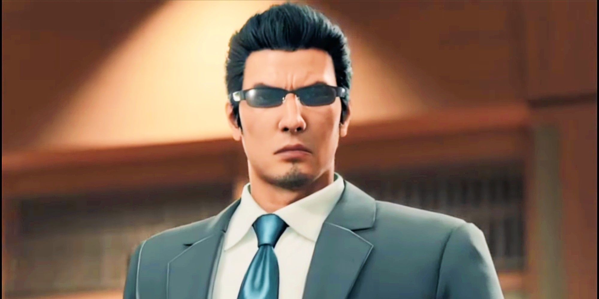 Kiryu's Outfit is a muted gray suit with a silky, light blue tie. He is wearing sunglasses.