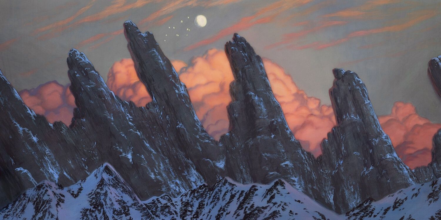 Mountains like claws with clouds behind and snow in front