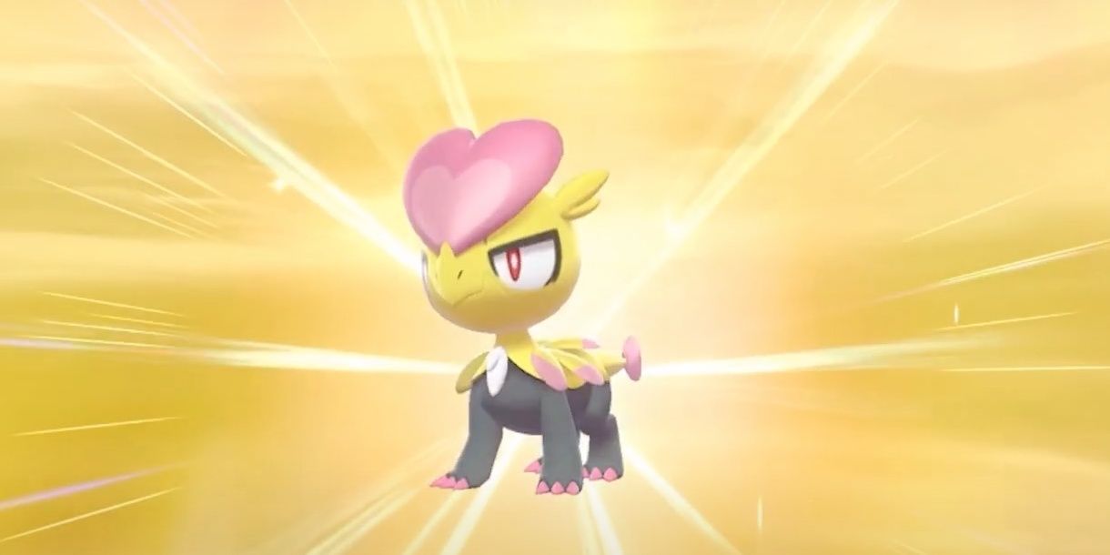 A freshly hatched shiny Jangmo-o on a yellow background