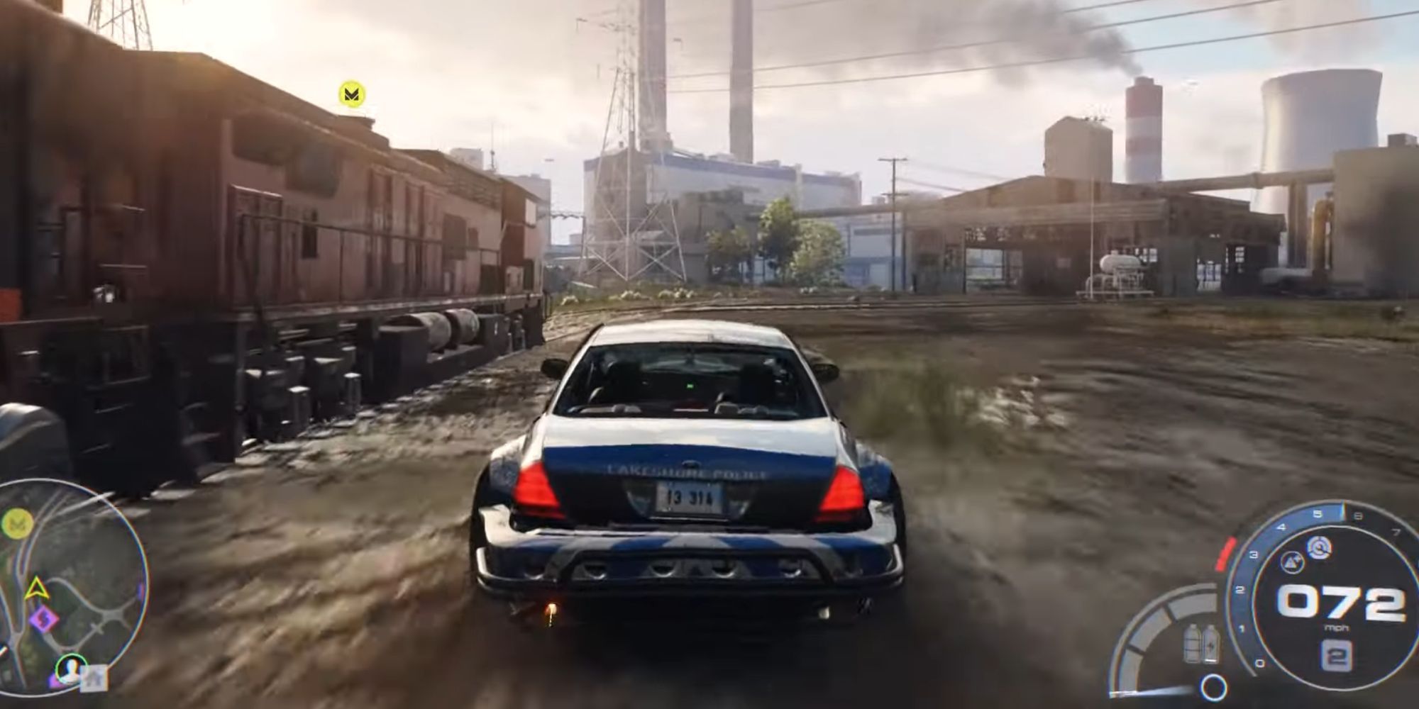 A blue car driving next to a moving train.