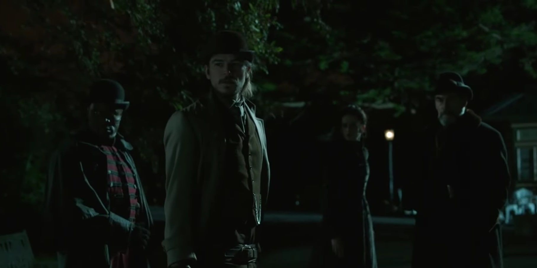 Ethan Chandler, Sembene, Vanessa Ives, and Malcolm Murray looking bewildered as they're surrounded by wolves in an empty zoo.