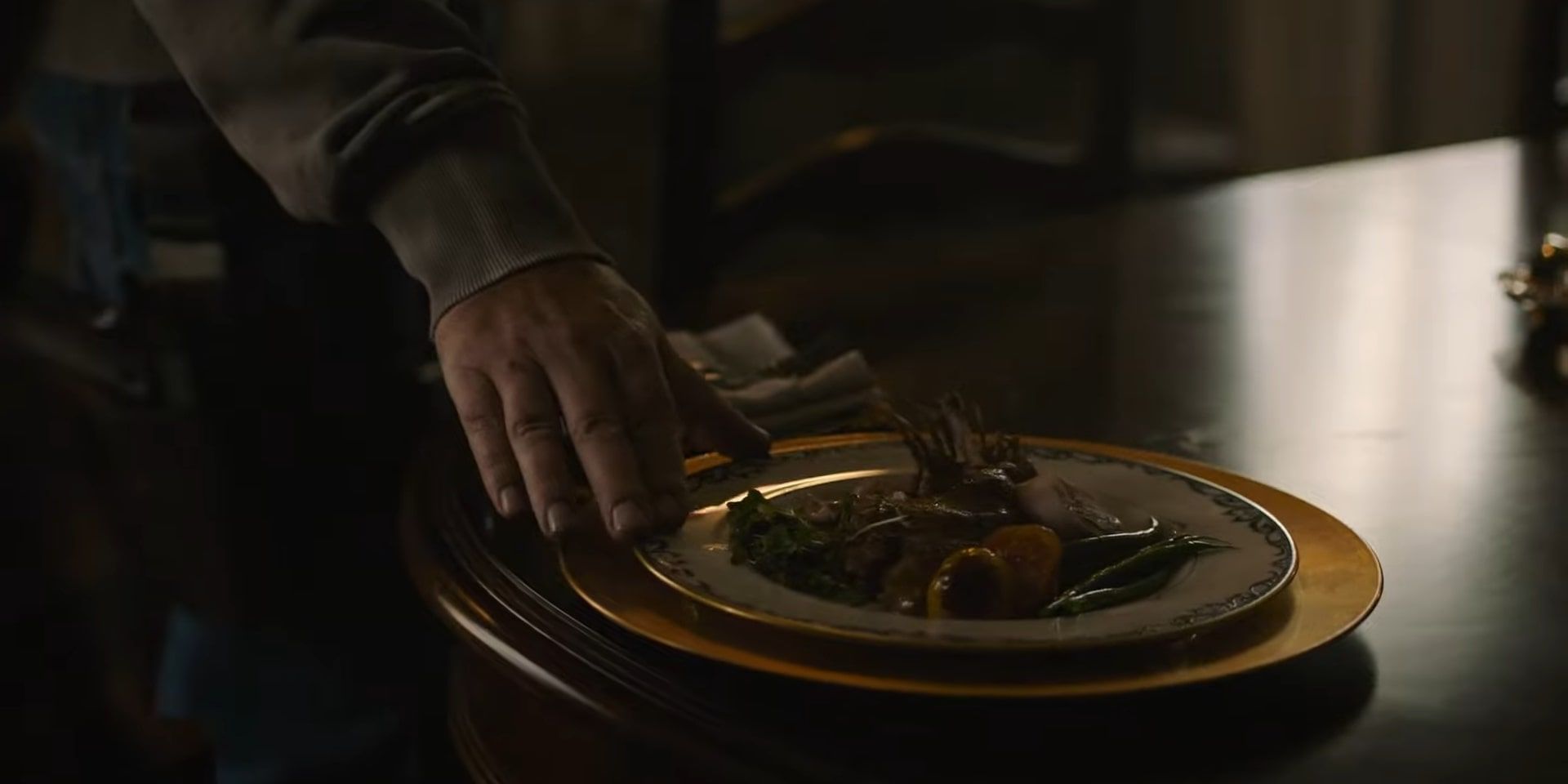 Bill putting a large plate of gourmet food down for Frank, with his hand holding the edge for a shot.