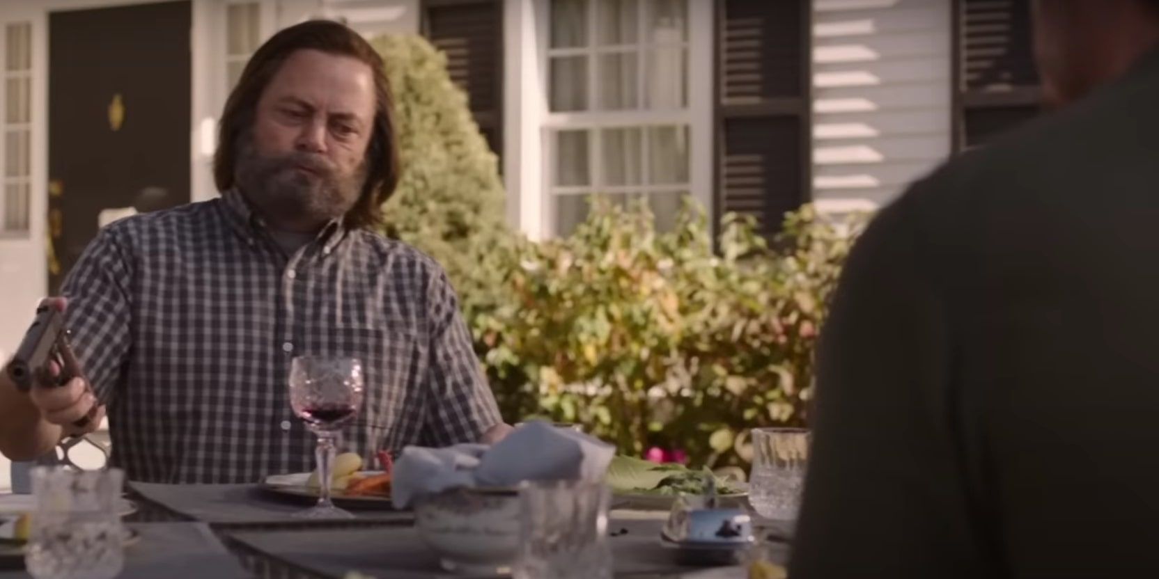 Bill cocking a handgun and holding it close on top of the table while he eats across from Joel, as he feels Joel is a threat.
