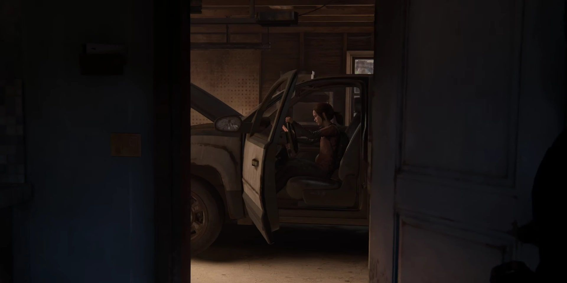 Ellie being silly and pretending to drive the steering wheel of Bill's immobile truck with its hood open.