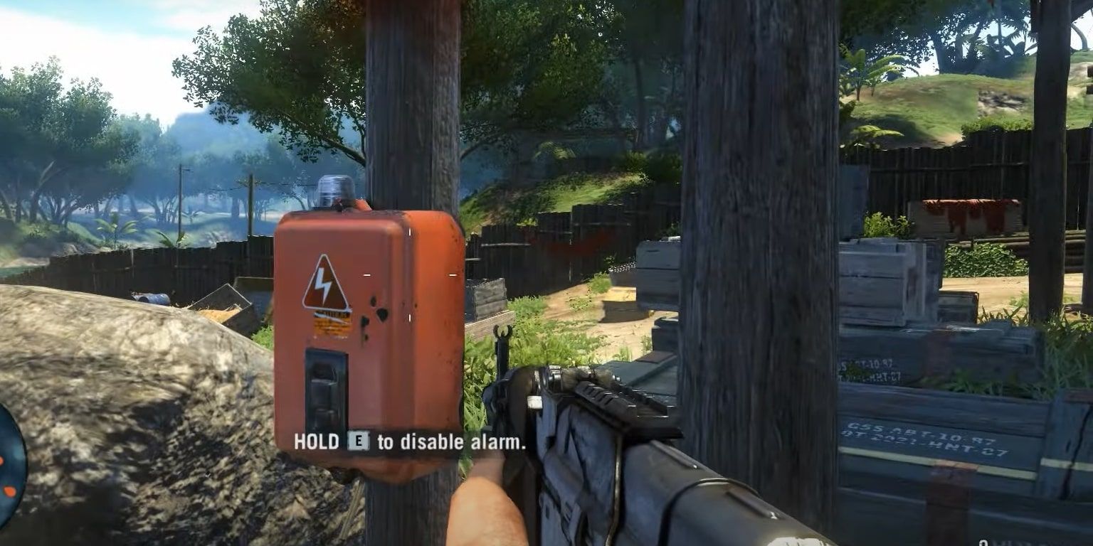 The player holding an AK weapon as a prompt to hold a button to disable the red alarm box in front of them appears on-screen.